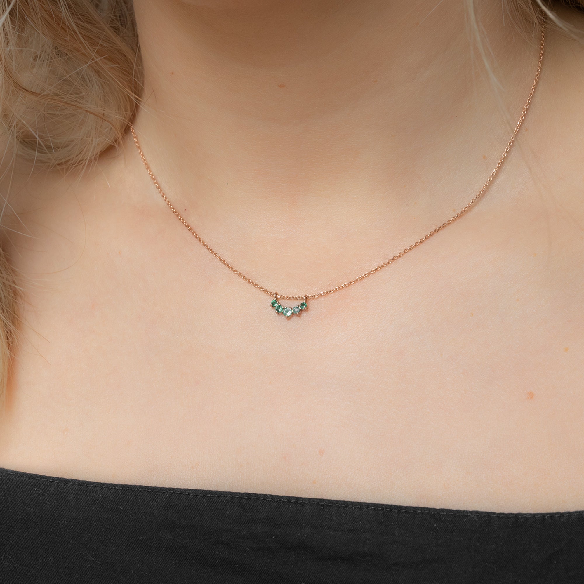 Custom Emerald Gemstone Sunburst Necklace | 10K Rose Gold. Displayed on model's neck.