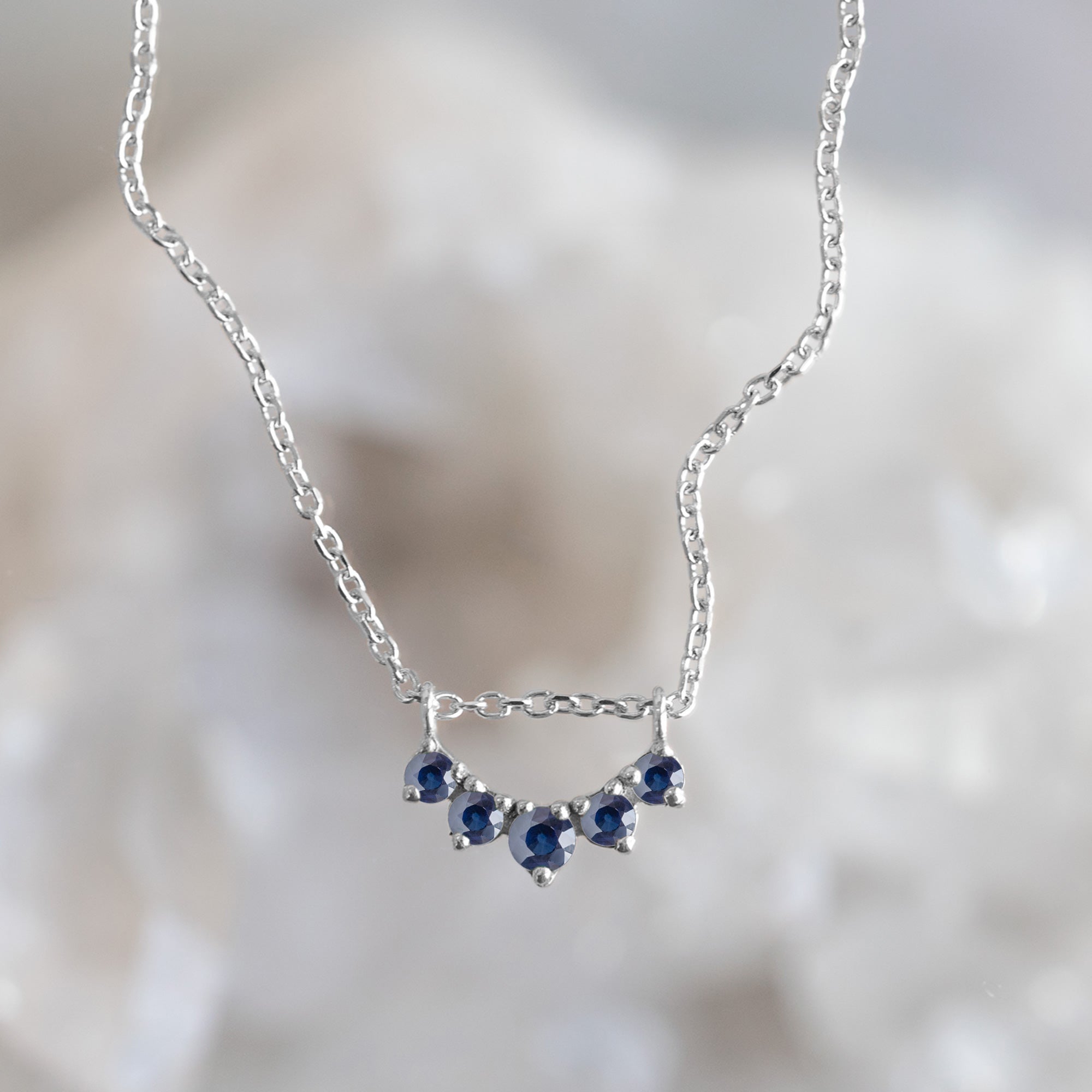 Custom Blue Sapphire Gemstone Sunburst Necklace | 10K White Gold with mirrored background.