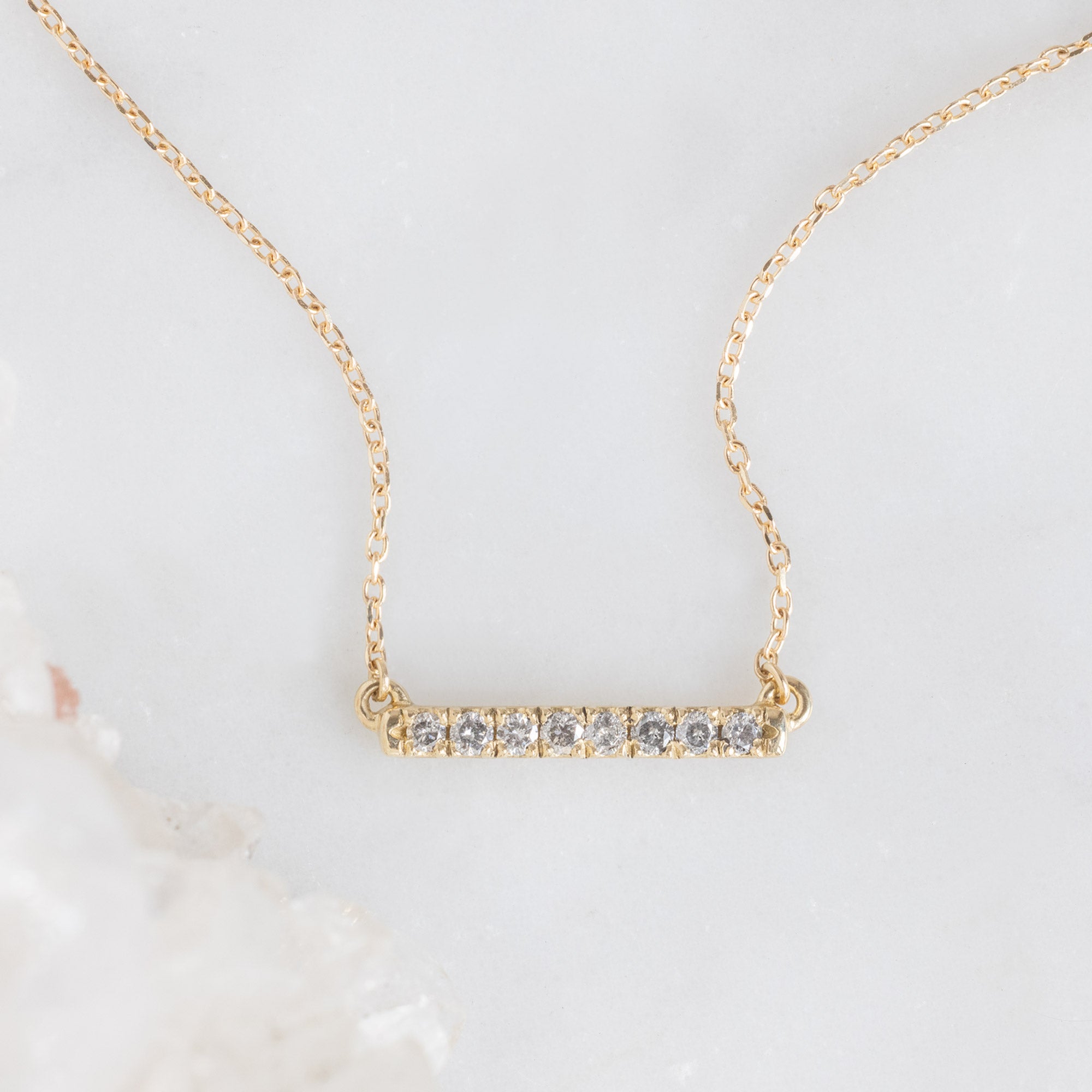 The Salt and Pepper Diamond Bar Necklace in Yellow Gold on White Marble