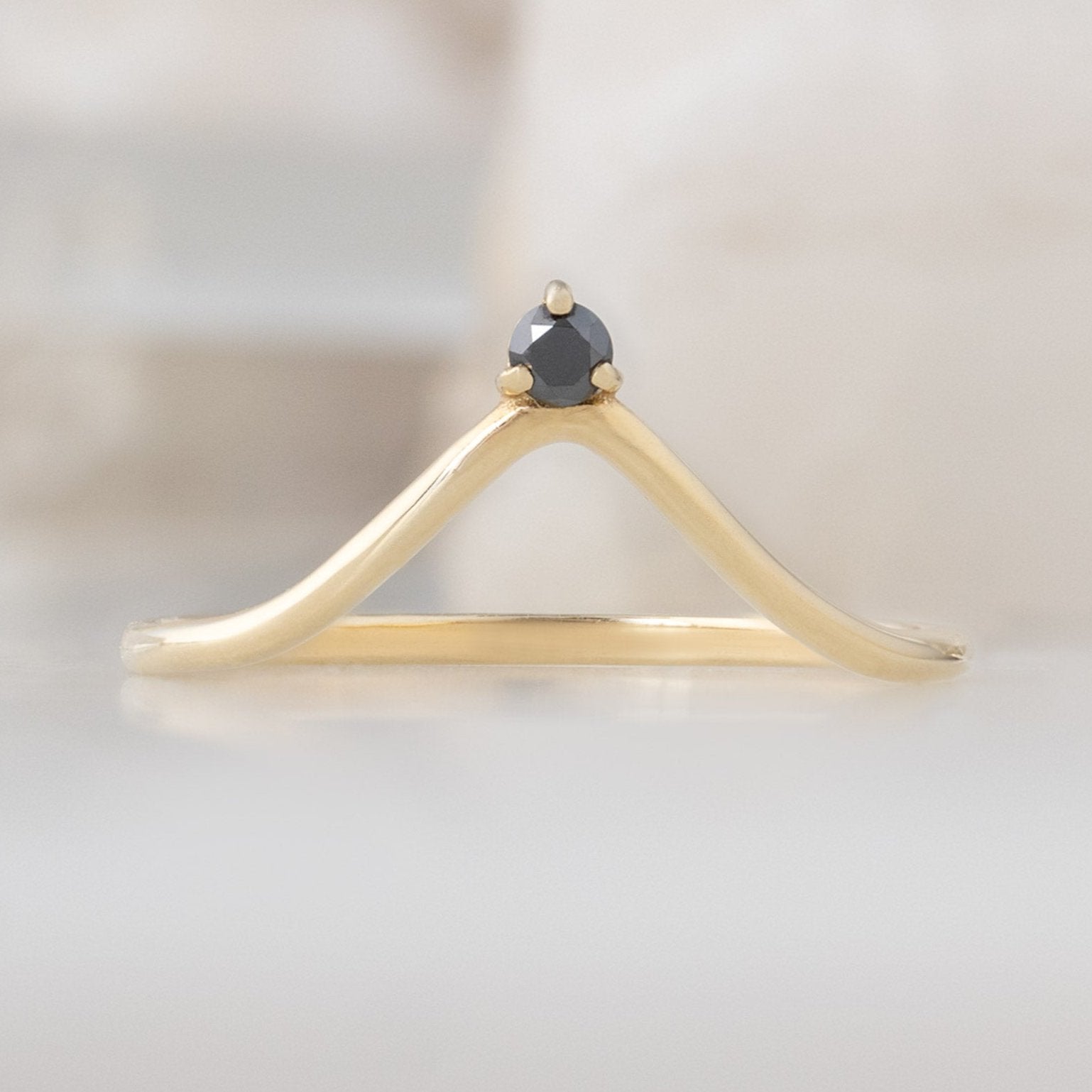 Black Diamond Crown Stacking Band in 14K Yellow Gold on White Marble