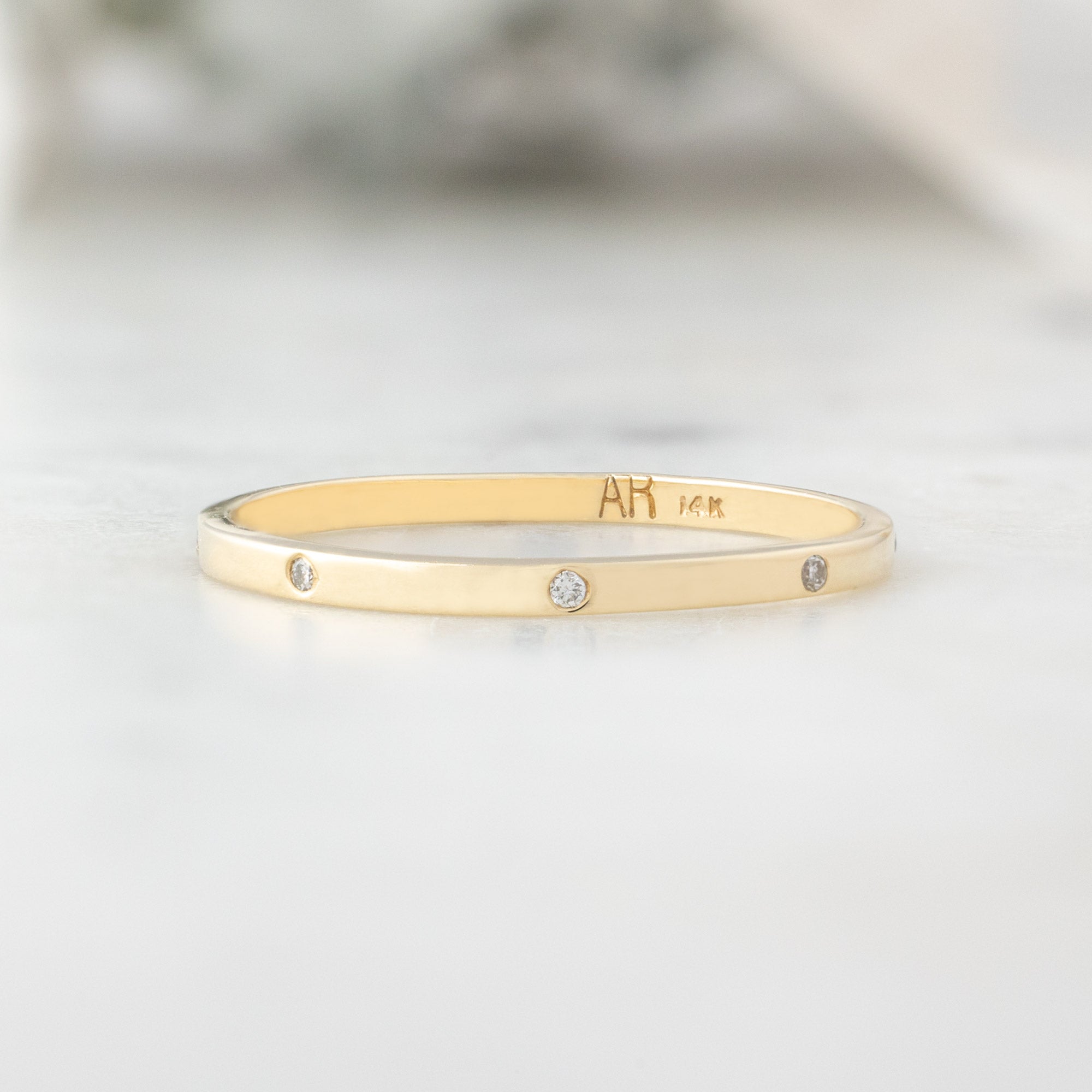 White Diamond Eternity Band in 14K Yellow Gold on White Marble