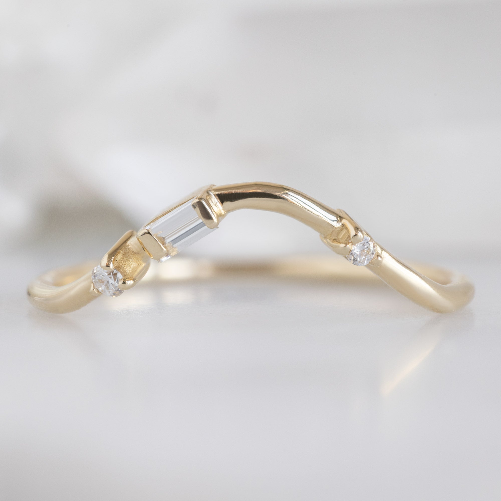 Asymmetrical Baguette Diamond Arc Stacking Band in 14K Yellow Gold on White Marble