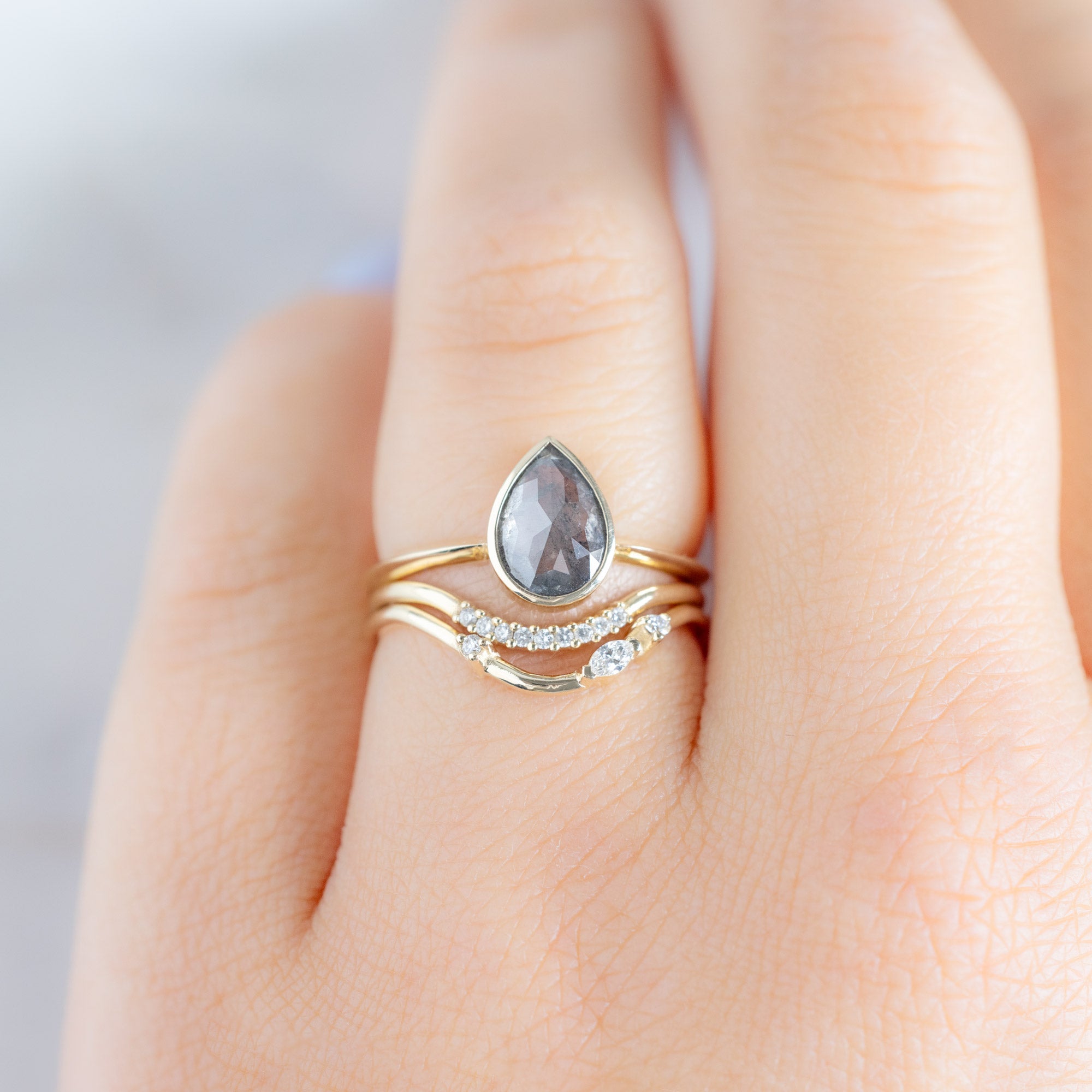 Asymmetrical Marquise Diamond Arc Stacking Band in 14K Yellow Gold Stacked with a Grey Pear Shaped Diamond Engagement Ring on Model