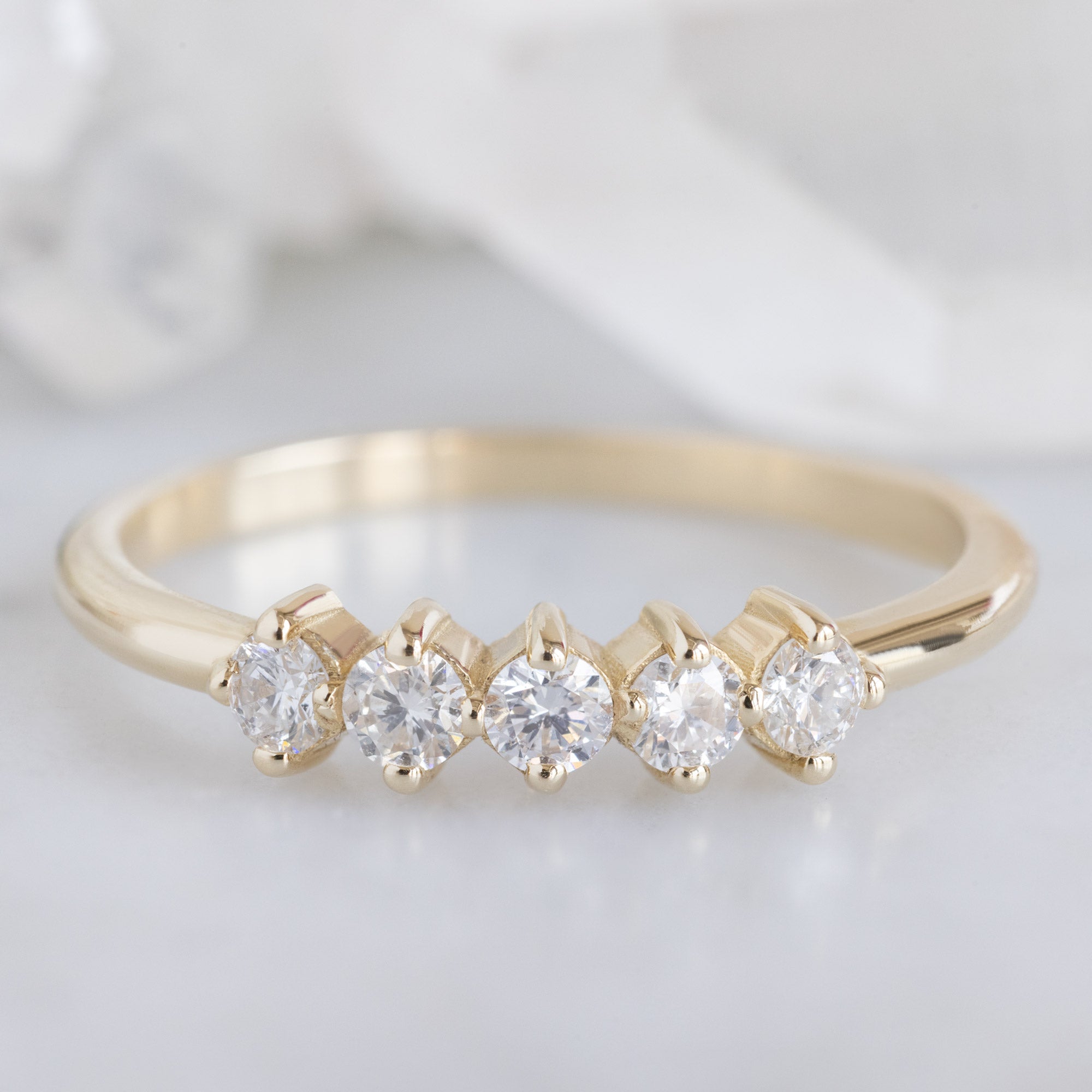 The Sequent White Diamond Wedding Band in 14K Yellow Gold on White Marble