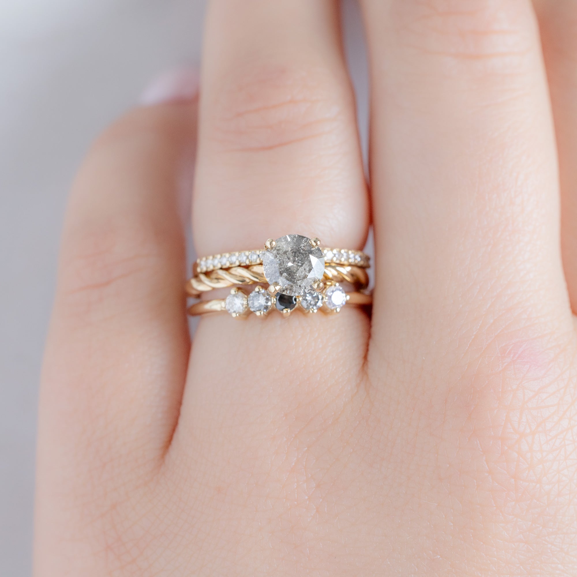 The Sequent Ombré Diamond Wedding Band in 14K Yellow Gold Stacked with Round Salt and Pepper Diamond Engagement Ring on Model