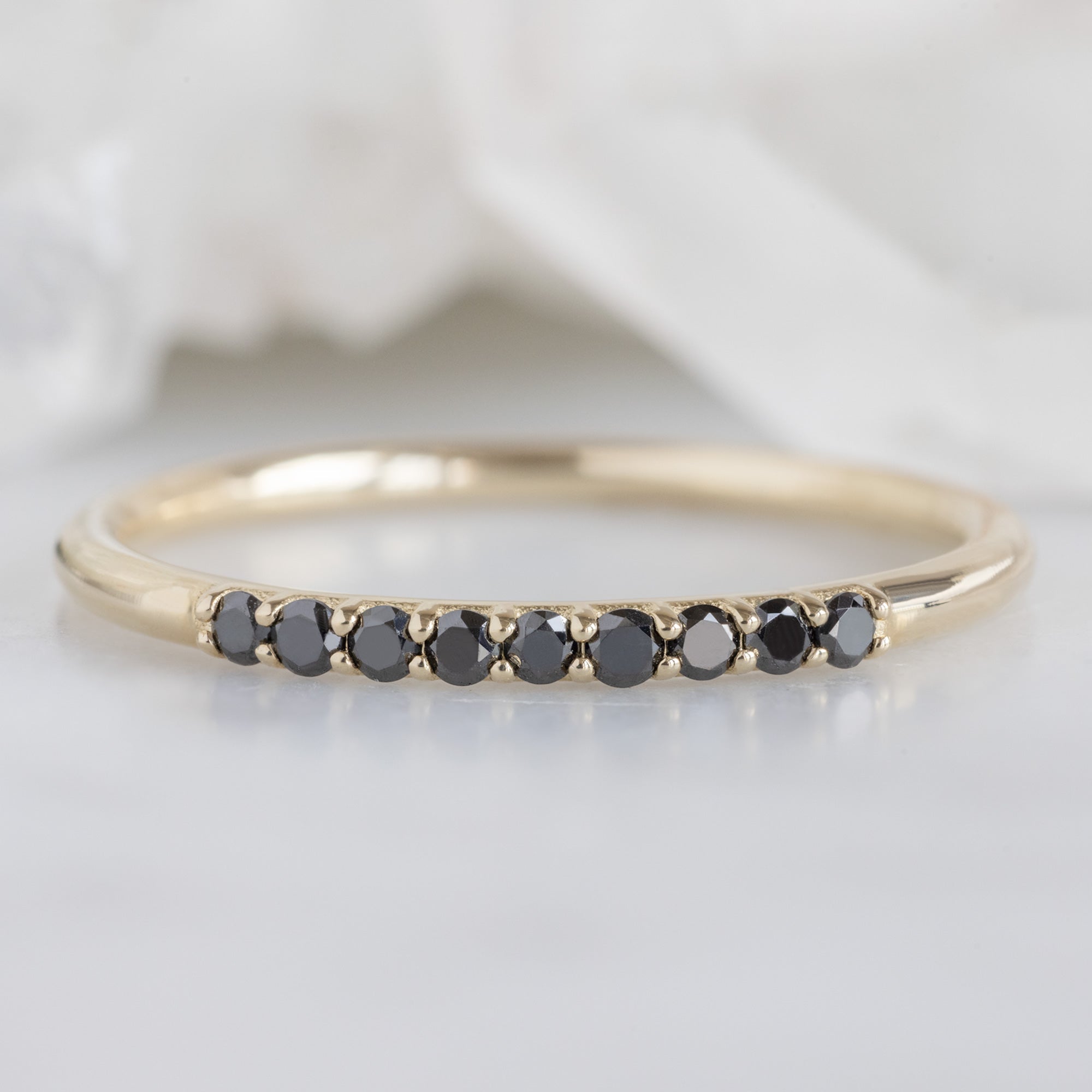The Luxe Black Diamond Pavé Wedding Band in 14K Yellow Gold on White Marble