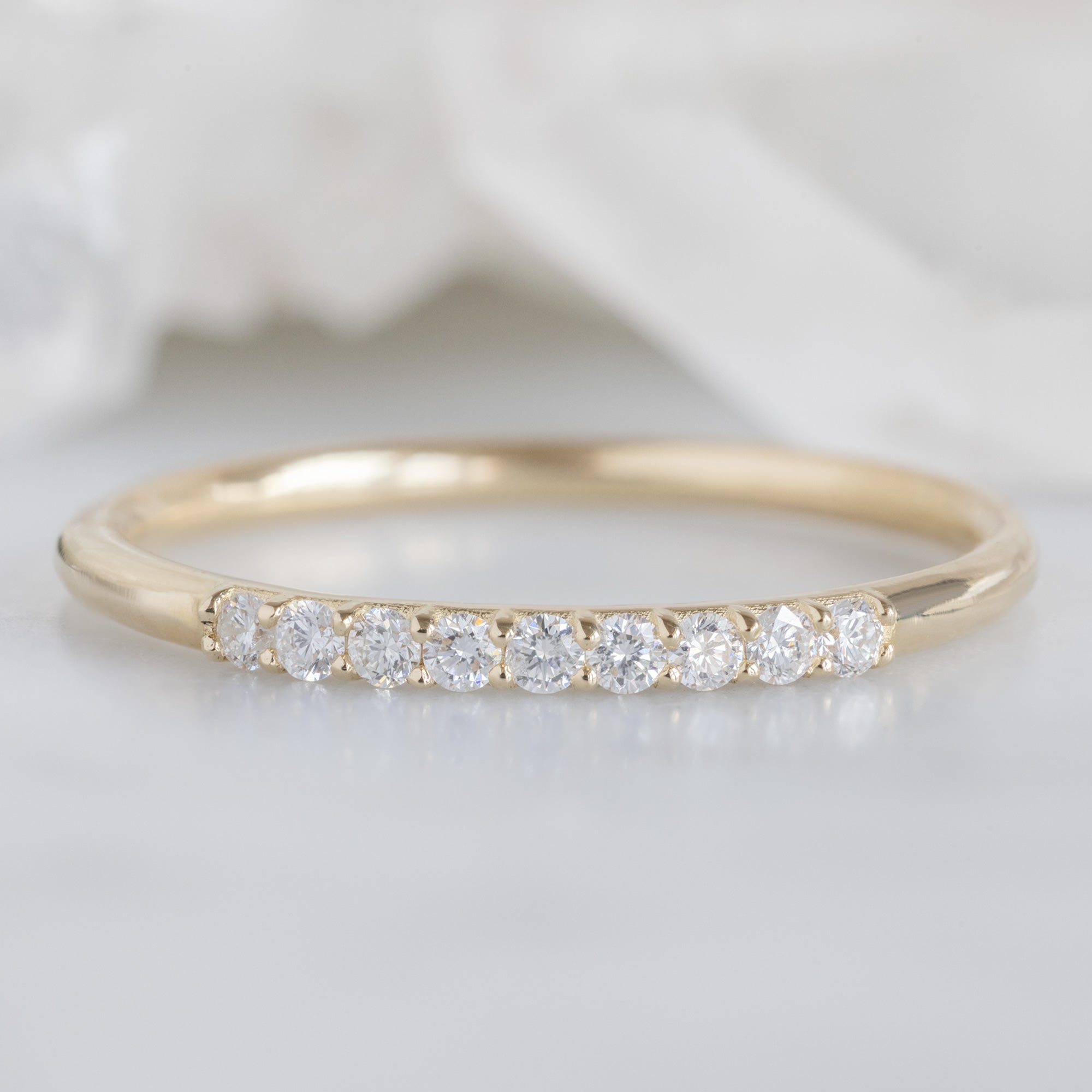 The Luxe White Diamond Pavé Wedding Band in 14k Yellow Gold on White Marble