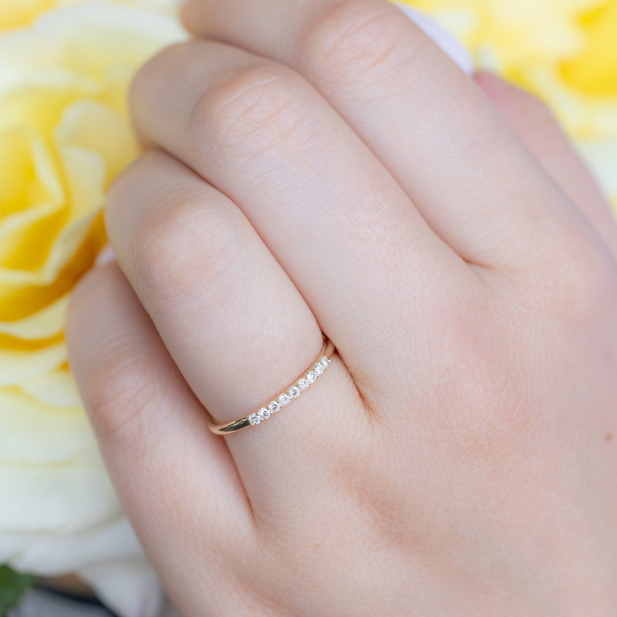 The Luxe White Diamond Pavé Wedding Band in 14k Yellow Gold on Model holding yellow roses