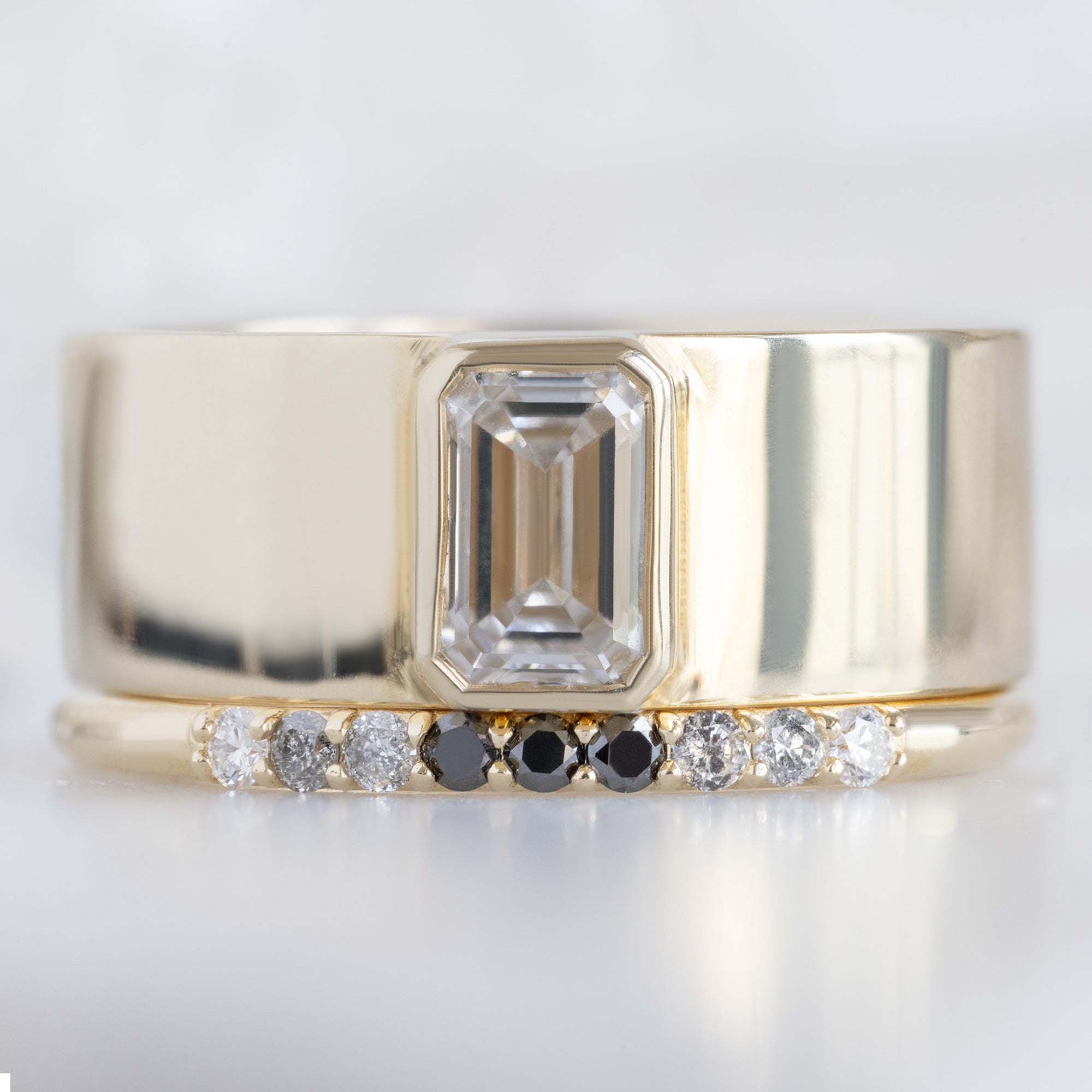 The Luxe Ombré Diamond Pavé Wedding Band in 14K Yellow Gold Stacked with White Diamond Cigar Band on White Marble