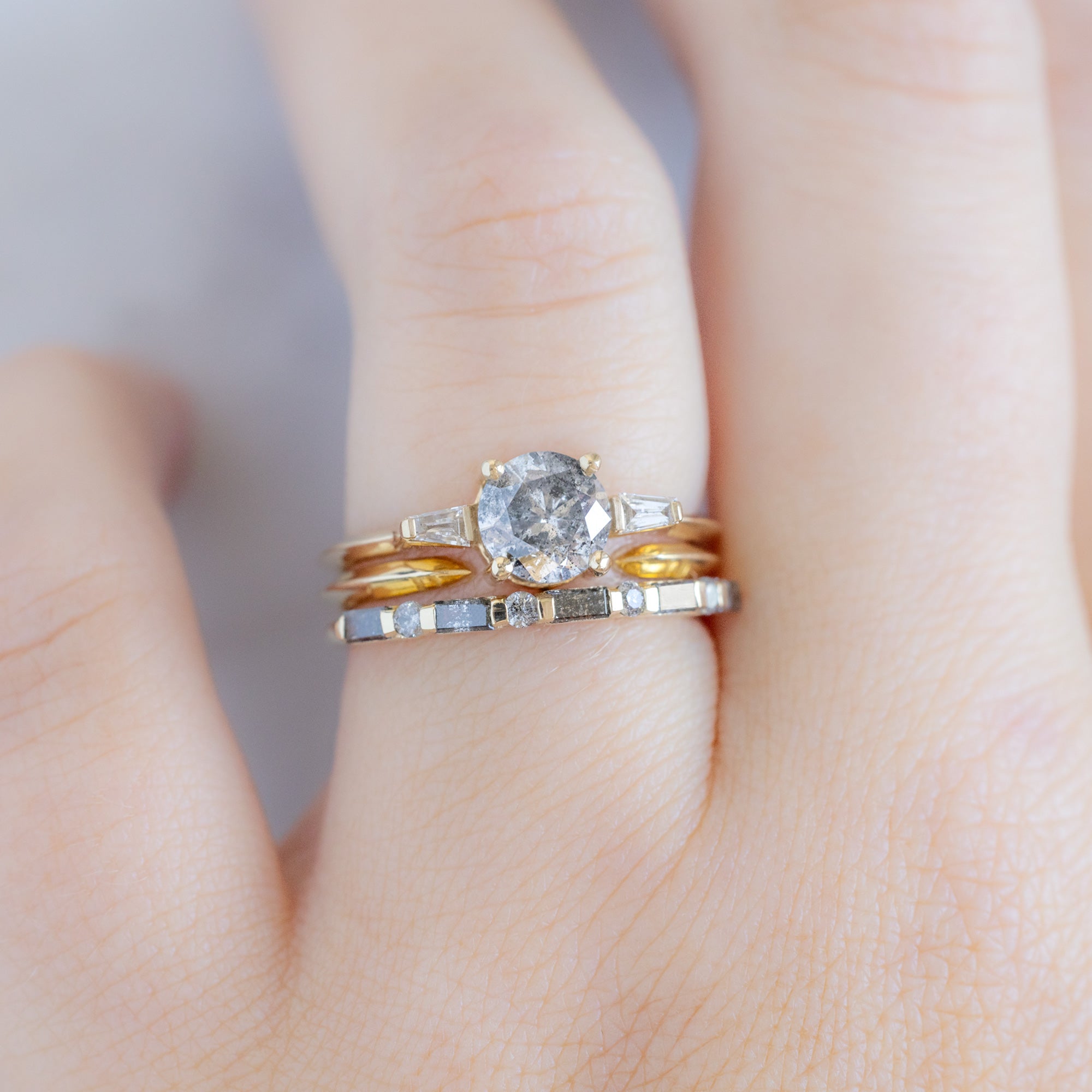 The Luxe Baguette Salt and Pepper Diamond Eternity Band in 14K Rose Gold stacked with round salt and pepper diamond engagement ring on model
