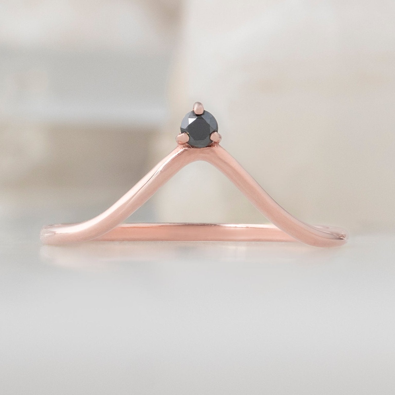Black Diamond Crown Stacking Band in 14K Rose Gold on White Marble Tile