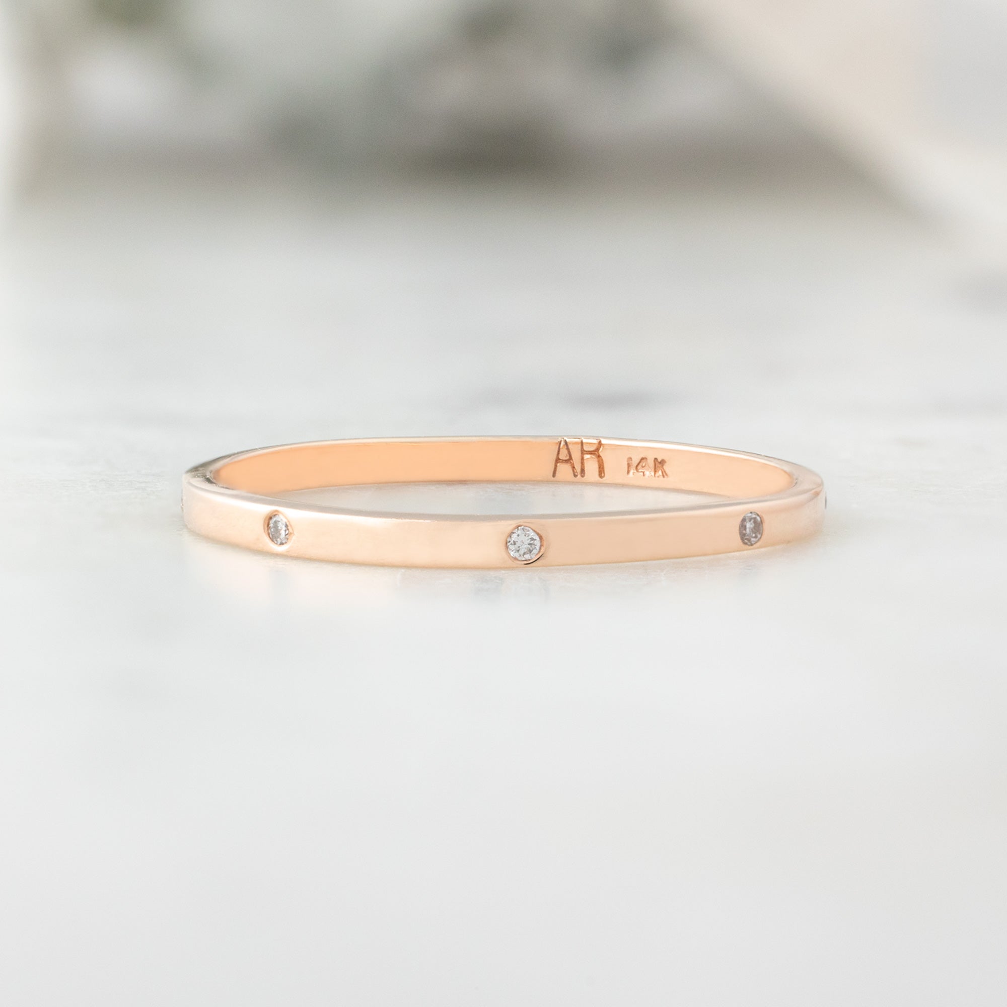 White Diamond Eternity Band in 14K Rose Gold on White Marble