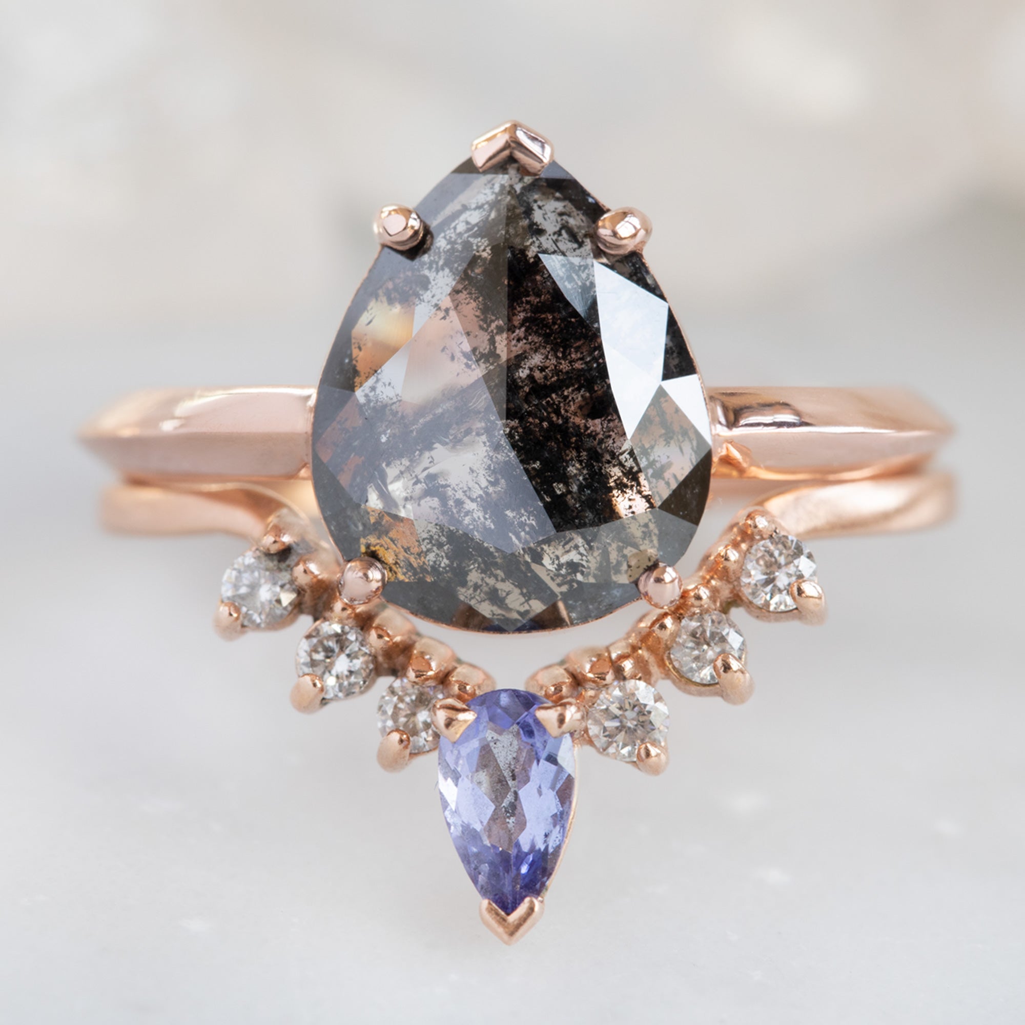 One of a Kind Tanzanite and White Diamond Sunburst Stacking Band in 14K Rose Gold Stacked with Black Pear Diamond Engagement Ring