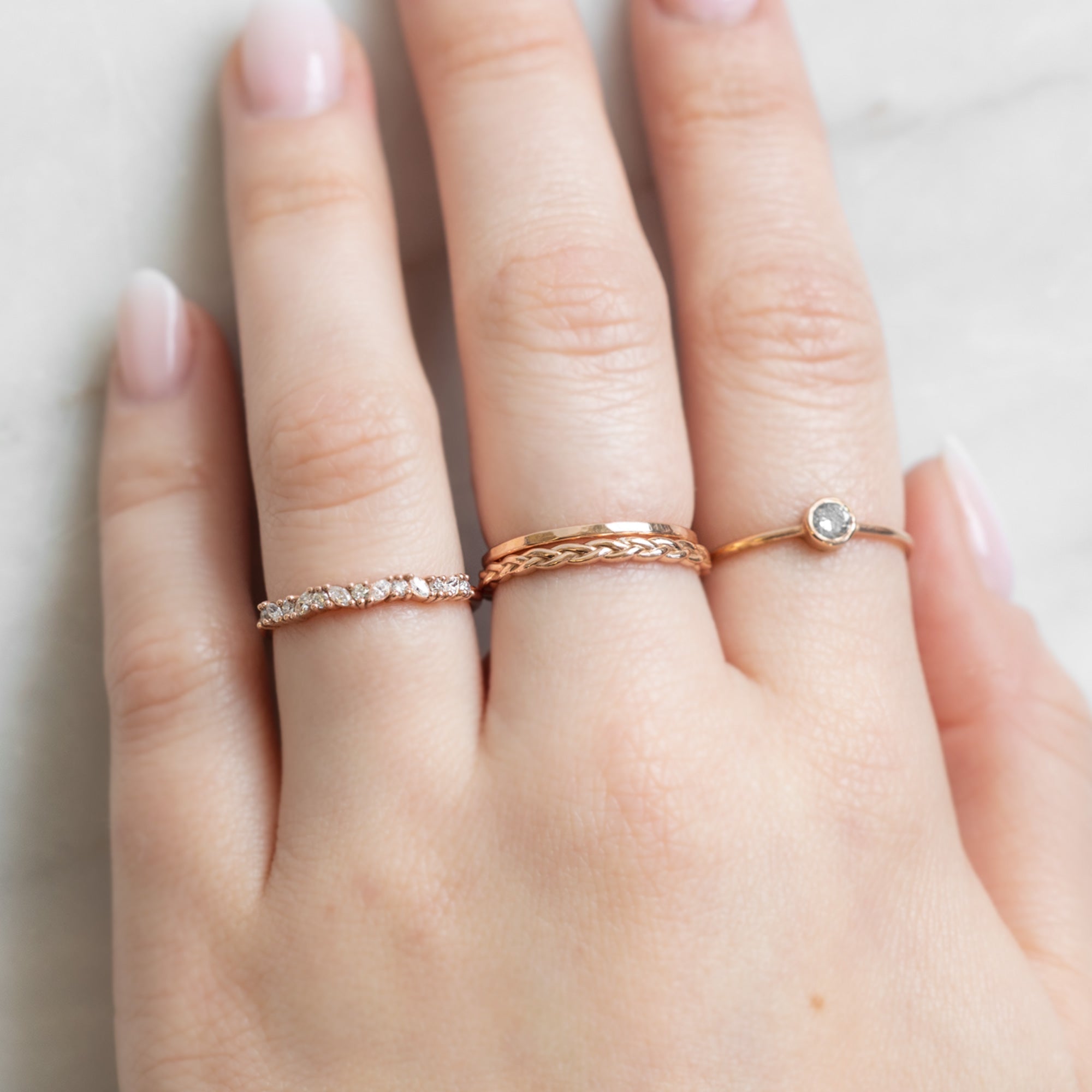 The Marquise Confetti Wedding Band in 14K Rose Gold Stacked with Fine Jewelry Rings on Model