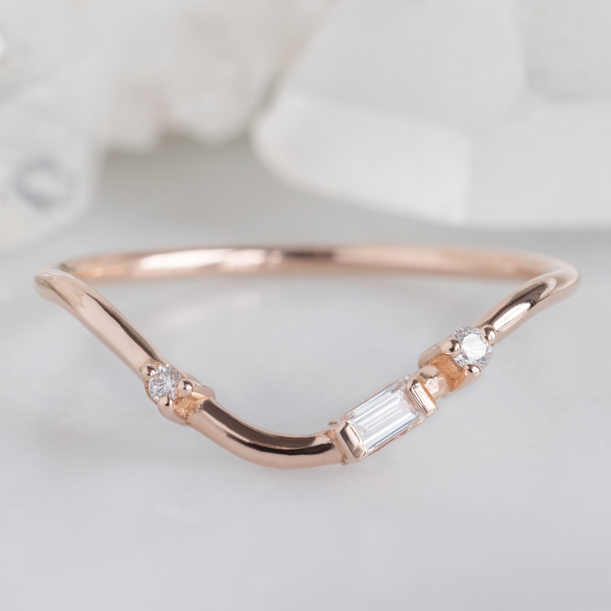 Asymmetrical Baguette Diamond Arc Stacking Band in 14K Rose Gold on White Marble