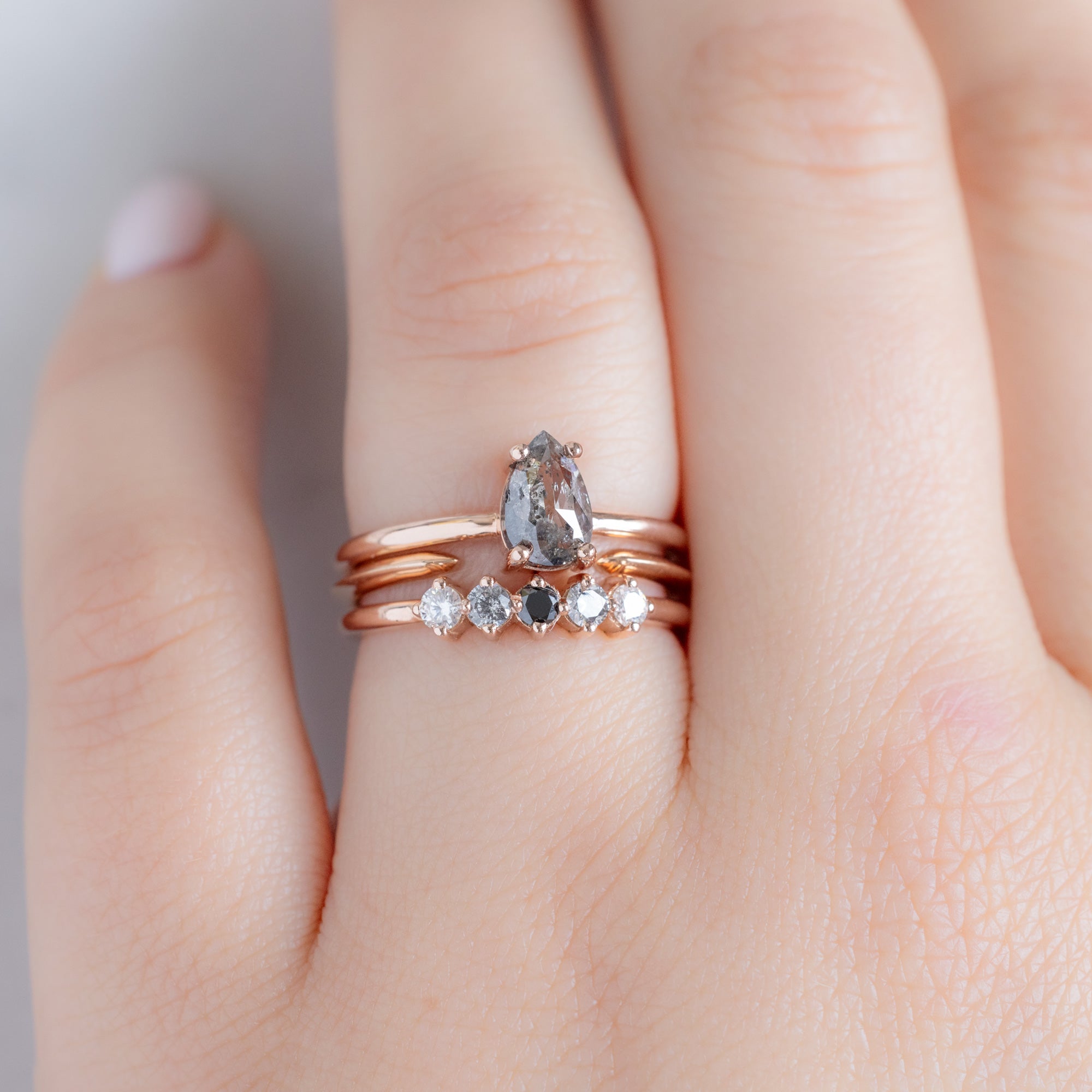 The Sequent Ombré Diamond Wedding Band in 14K Rose Gold Stacked with Pear Salt and Pepper Diamond Engagement Ring on Model