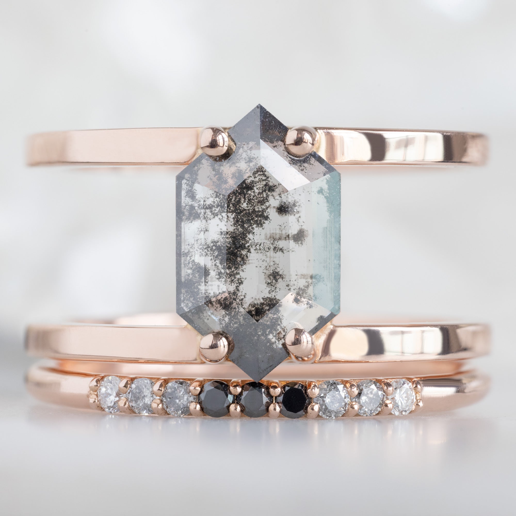 The Luxe Ombré Diamond Pavé Wedding Band in 14K Rose Gold Stacked with Double Band Salt and Pepper Diamond Engagement Ring on White Marble