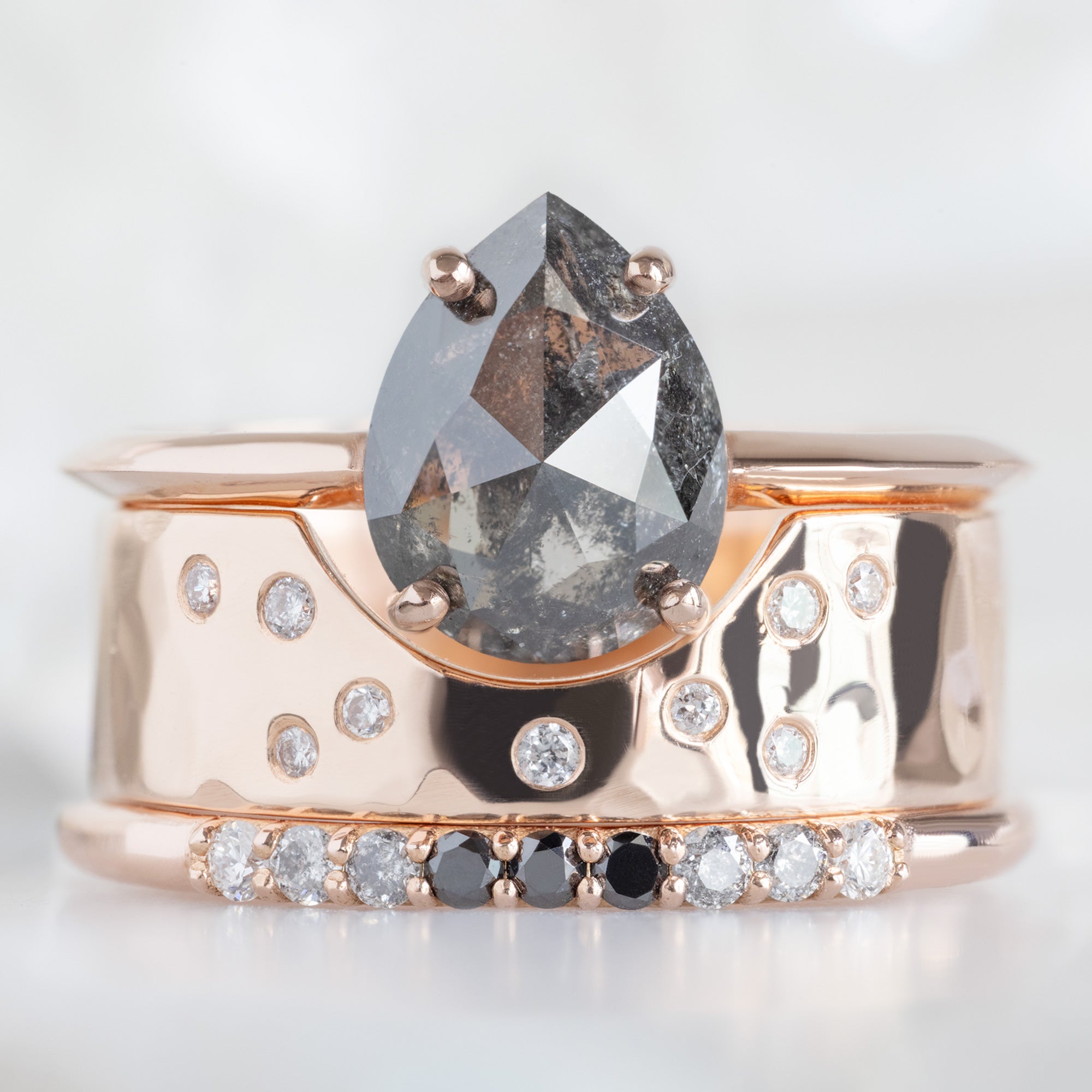 The Luxe Ombré Diamond Pavé Wedding Band in 14K Rose Gold  Stacked with Black Pear Diamond Engagement Ring on White Marble