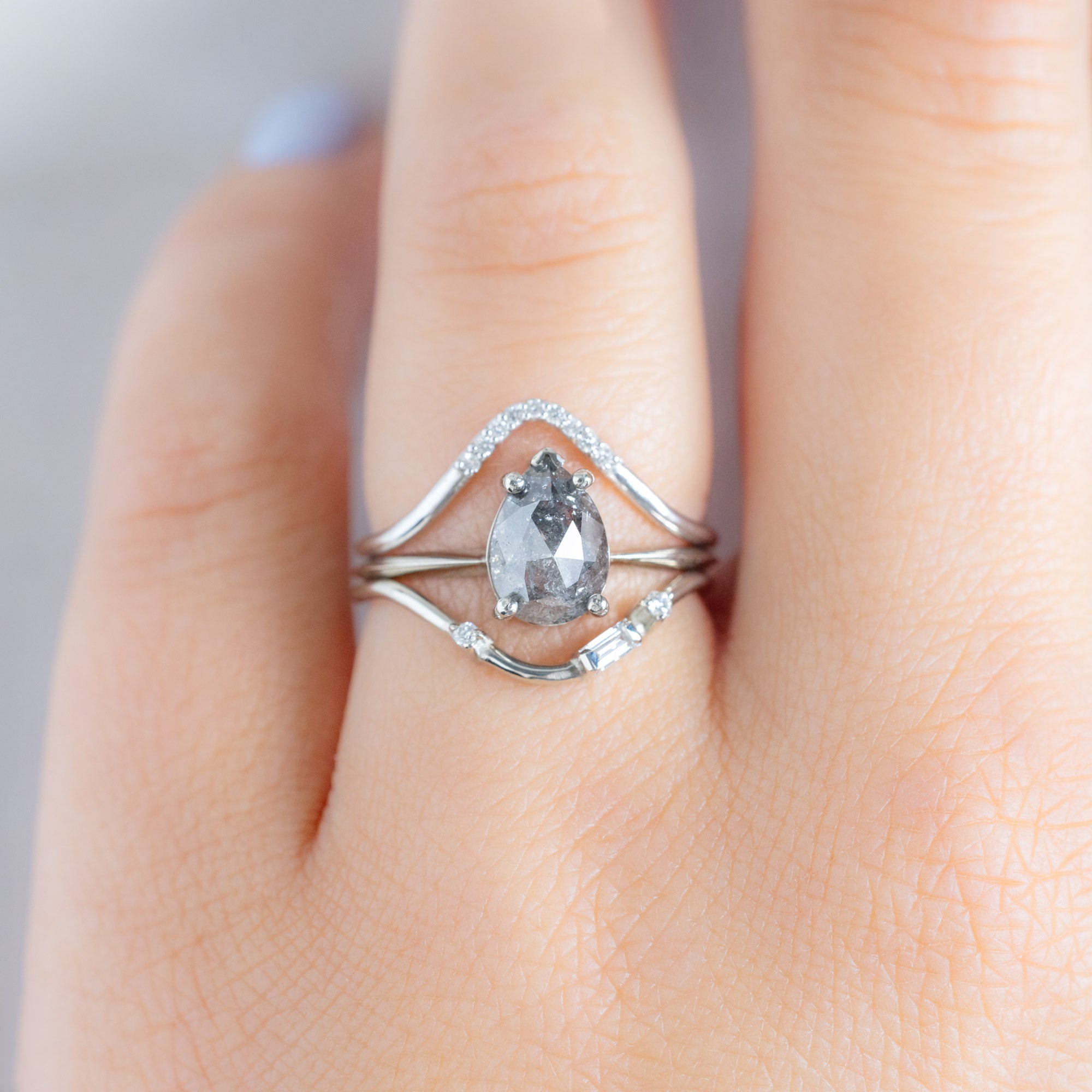 Asymmetrical Baguette Diamond Arc Stacking Band in 14K White Gold Stacked with a Salt and Pepper Pear Shaped Diamond Engagement Ring on Model