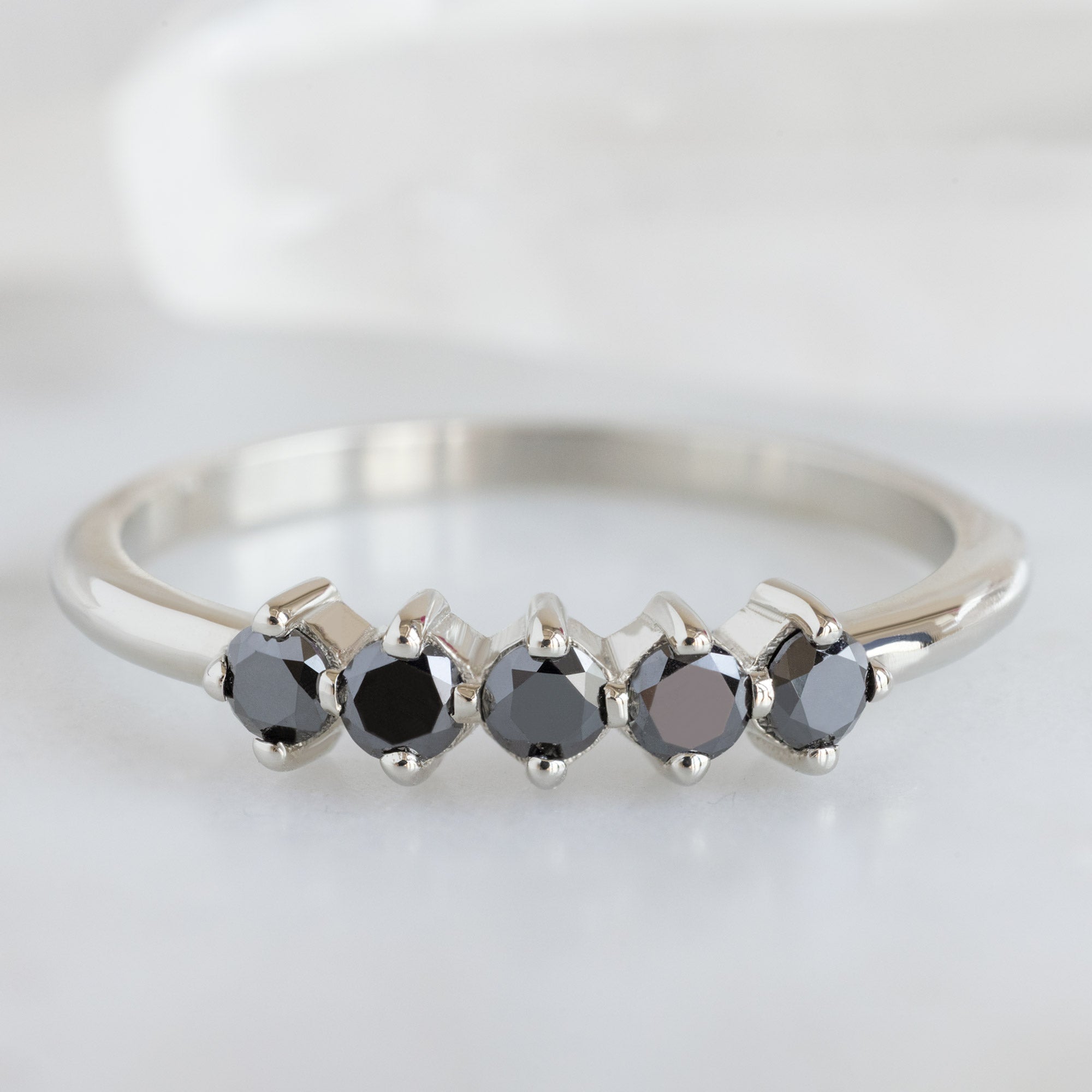The Sequent Black Diamond Wedding Band in 14K White Gold on White Marble