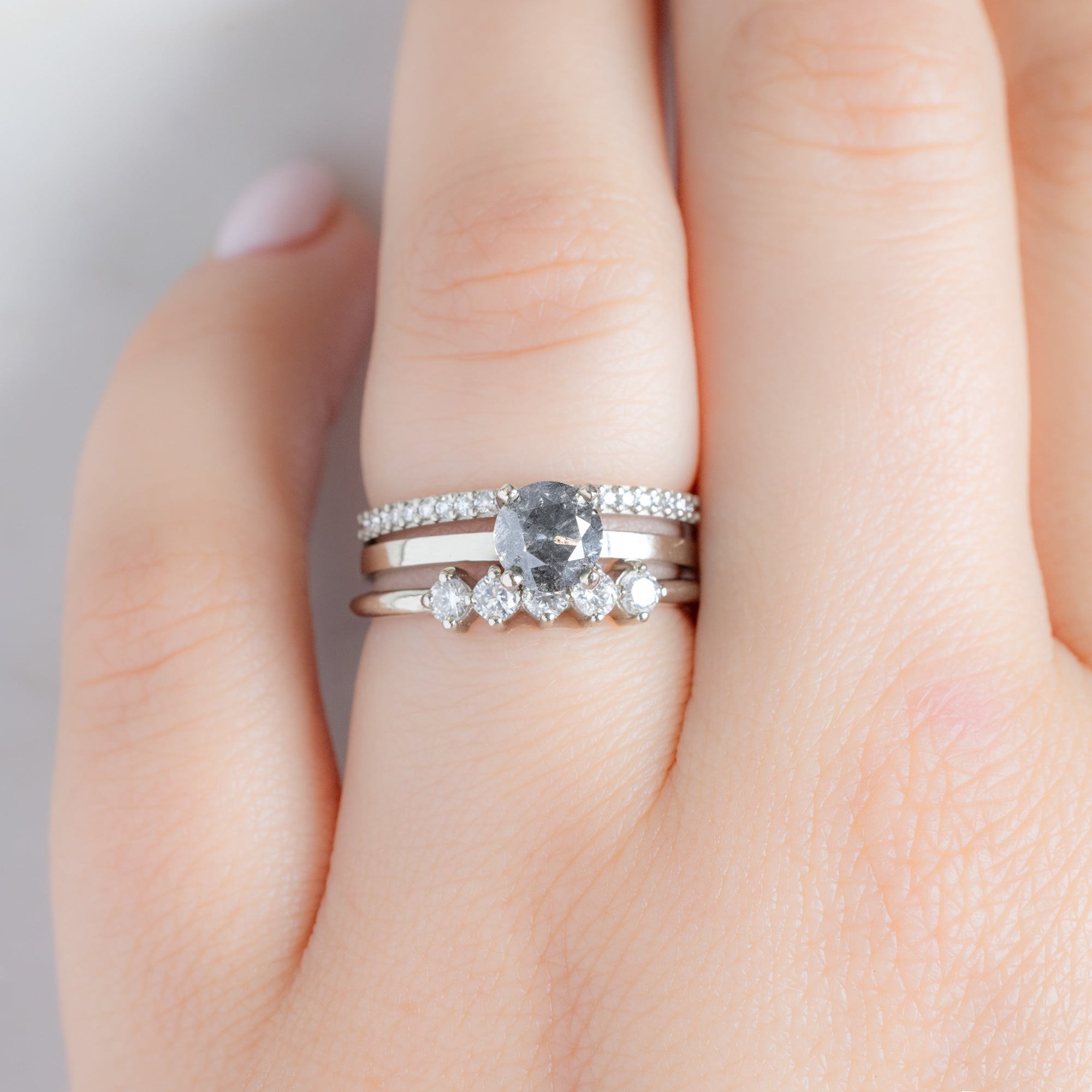 The Sequent White Diamond Wedding Band in 14K White Gold Stacked with Round Salt and Pepper Diamond Engagement Ring on Model