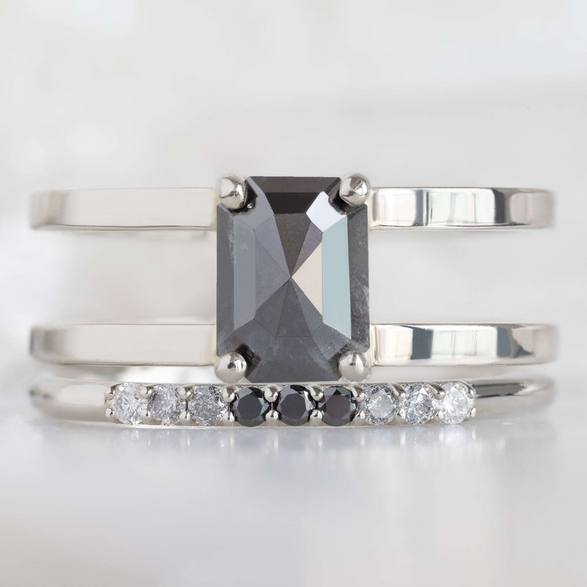 The Luxe Ombré Diamond Pavé Wedding Band in 14K White Gold Stacked with Double Band Black Diamond Engagement Ring on White Marble