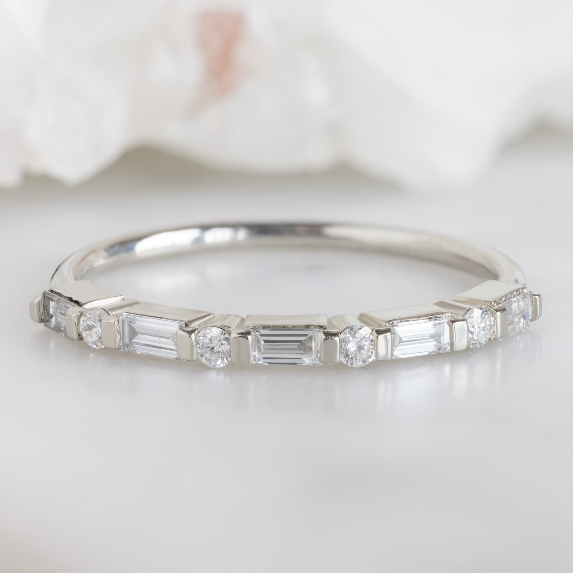 The Luxe Baguette White Diamond Eternity Band in 14K White Gold on white marble surface