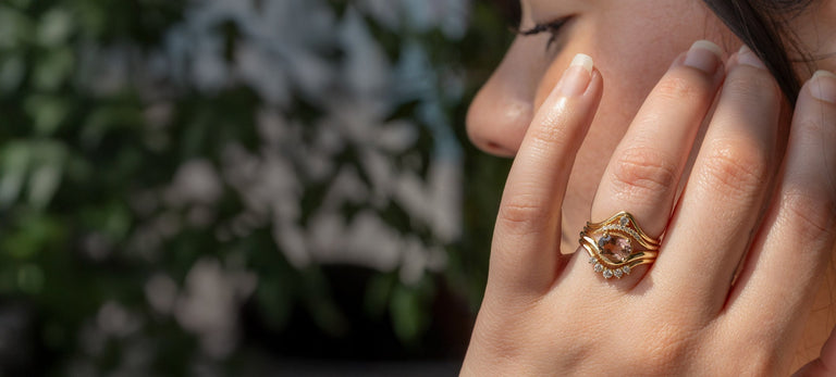 model wearing yellow gold gemstone engagement ring with stacking bands