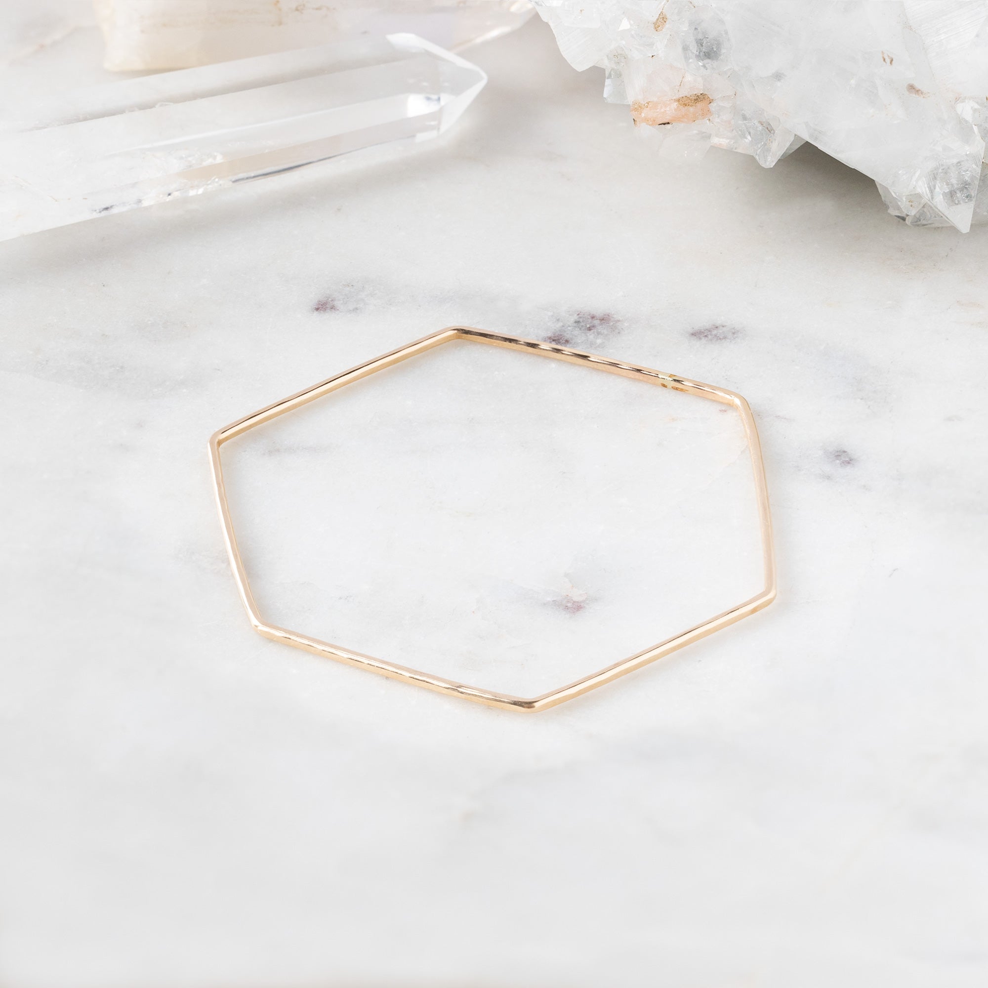 The Hex Stacking Bangle in Yellow Gold Filled on White Marble