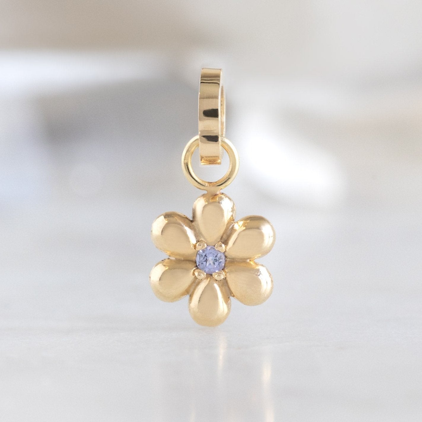 The Flower Power Charm in 10K Yellow Gold on White Marble