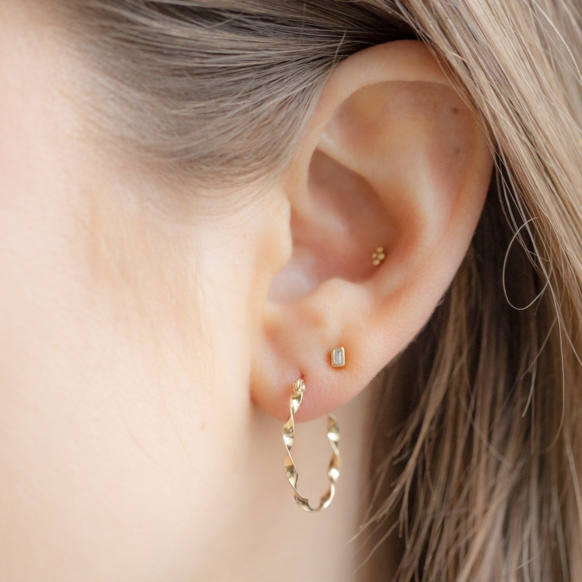 The Ribbon Hoops in 14K Yellow Gold stacked on model