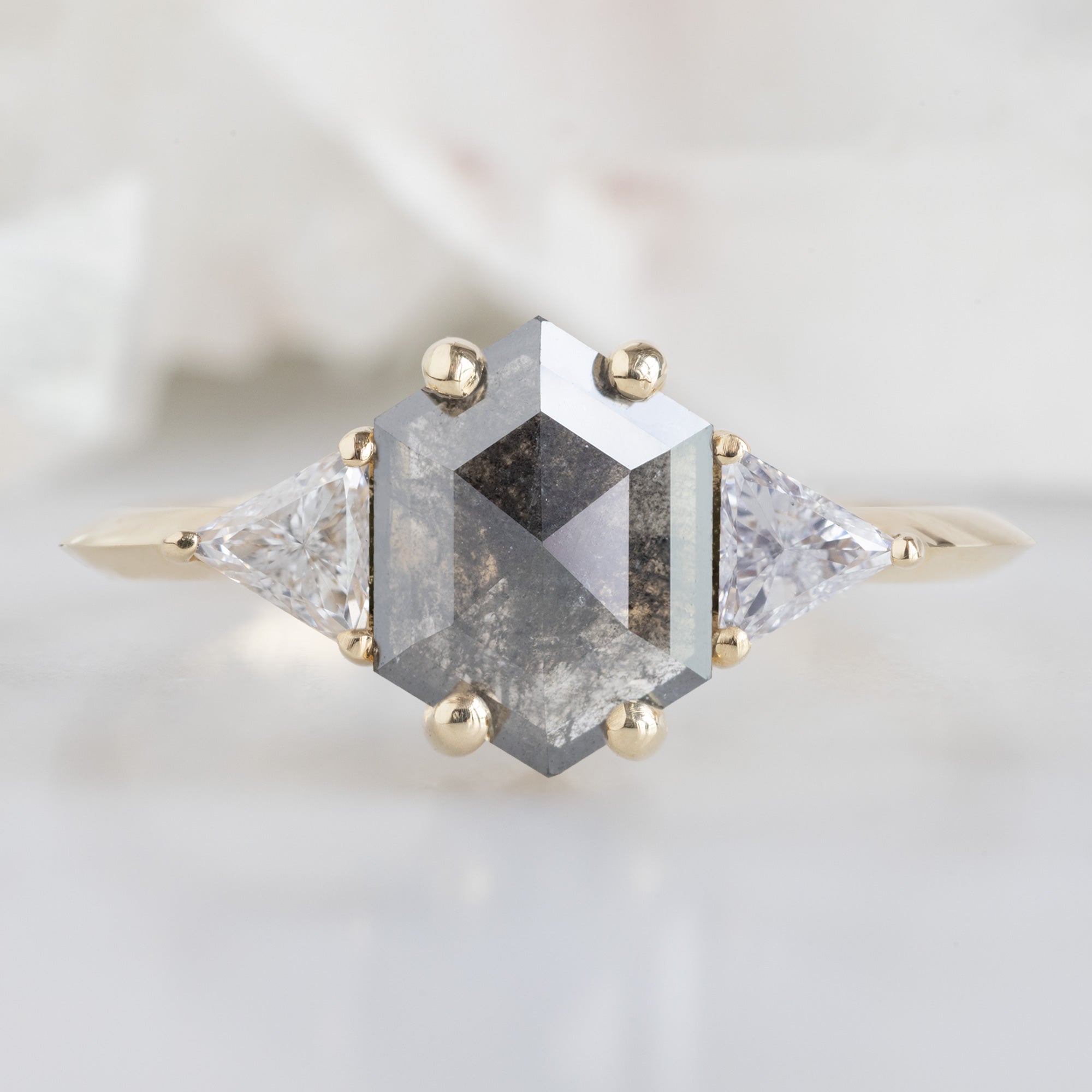 The Jade Ring with a 0.91ct Hexagonal Grey Diamond in 14K Yellow Gold on White Marble Surface