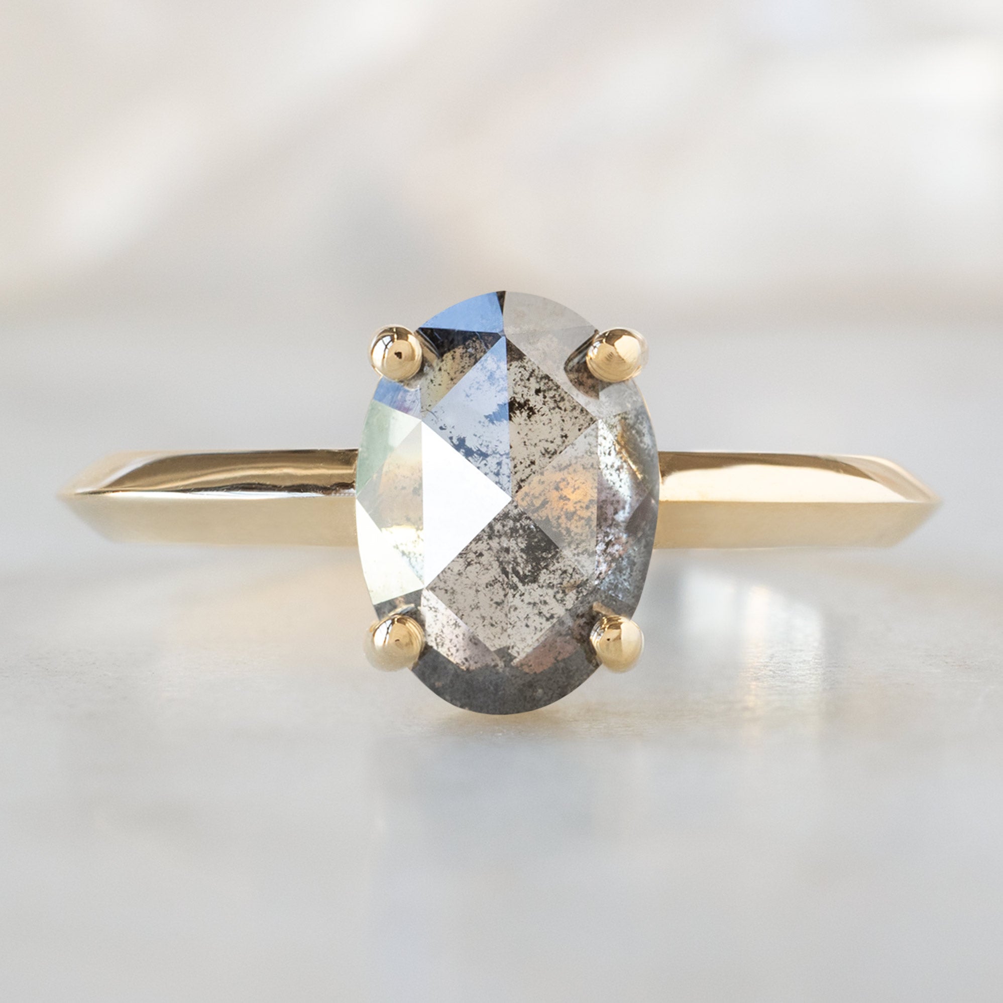The Bryn Ring with a 1.41ct Oval Salt and Pepper Diamond in 14K Yellow Gold on White Marble