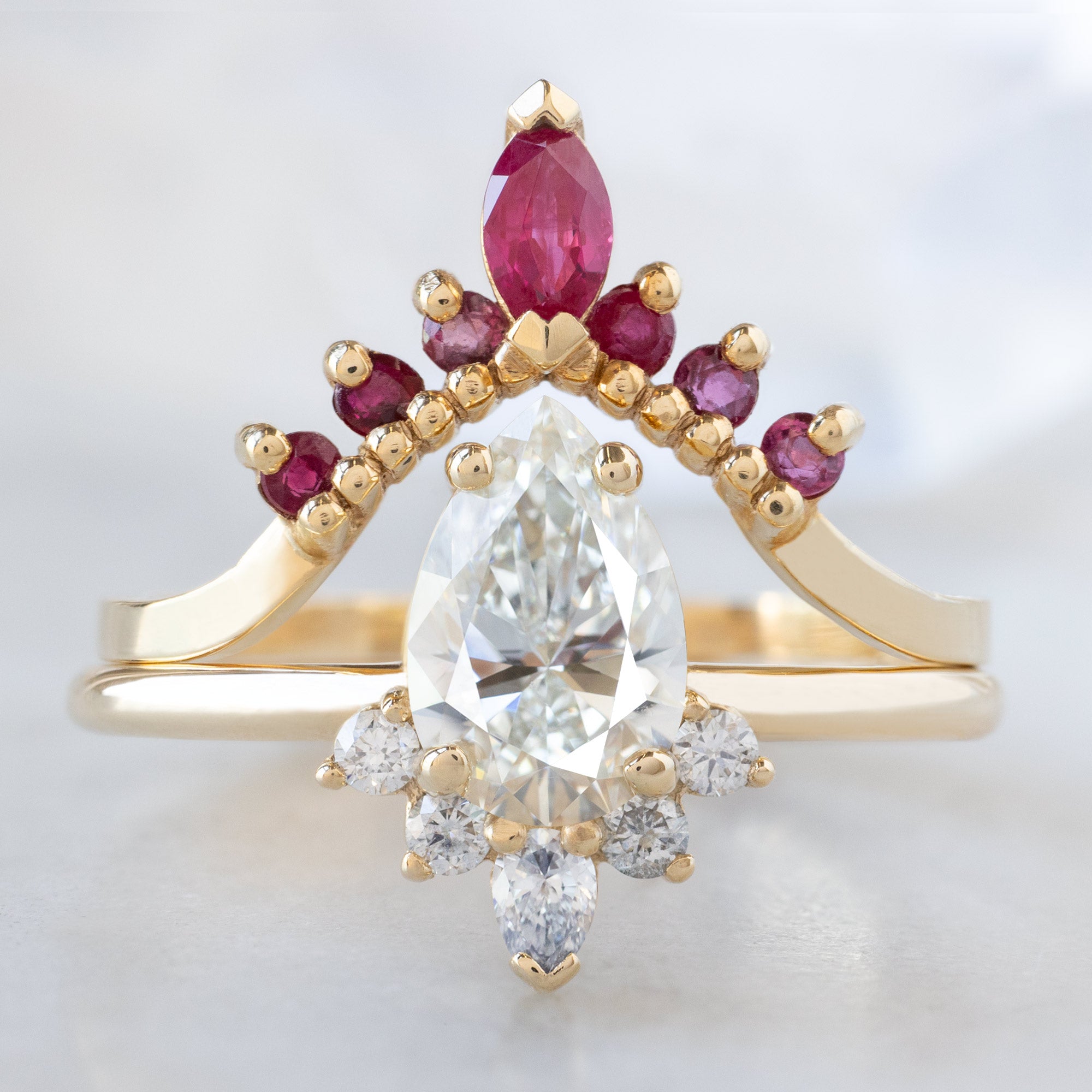 The Aster Ring with a 0.80ct Pear Natural White Diamond in 14K Yellow Gold Stacked with the Ruby Marquise Sunburst Stacking Band