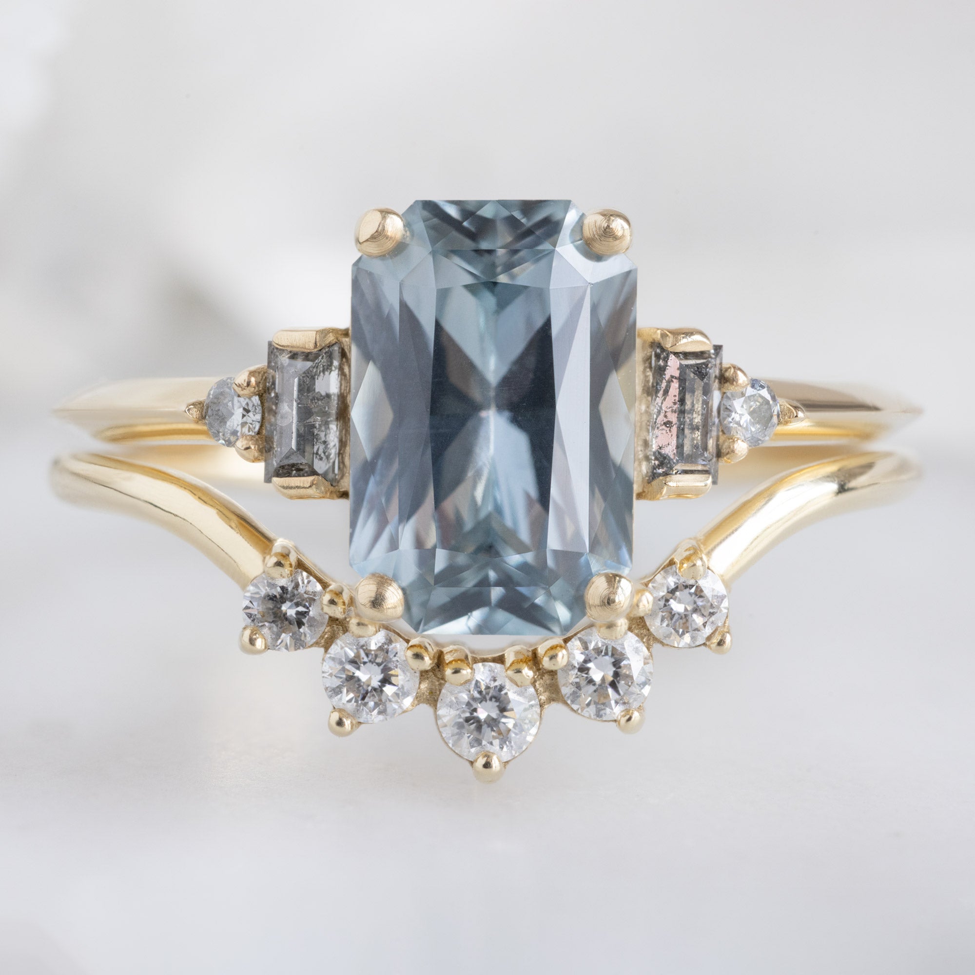 The Primrose Ring with a 2.00ct Emerald-Cut Blue Sapphire in 14K Yellow Gold Stacked with the Round White Diamond Sunburst Stacking Band