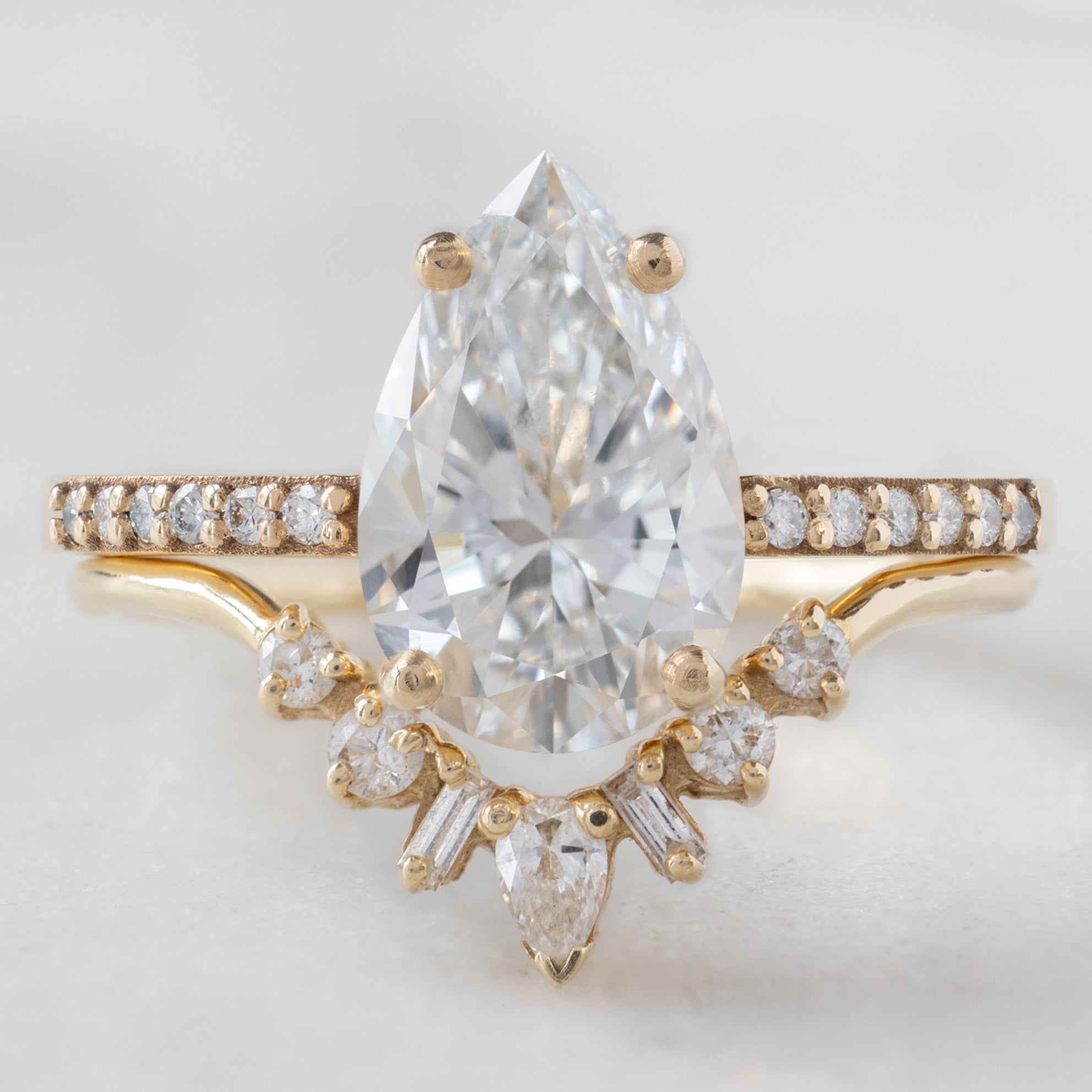 The Willow Ring with a Lab Grown Pear White Diamond in 14K Yellow Gold Stacked with the Geometric White Diamond Sunburst Stacking Band