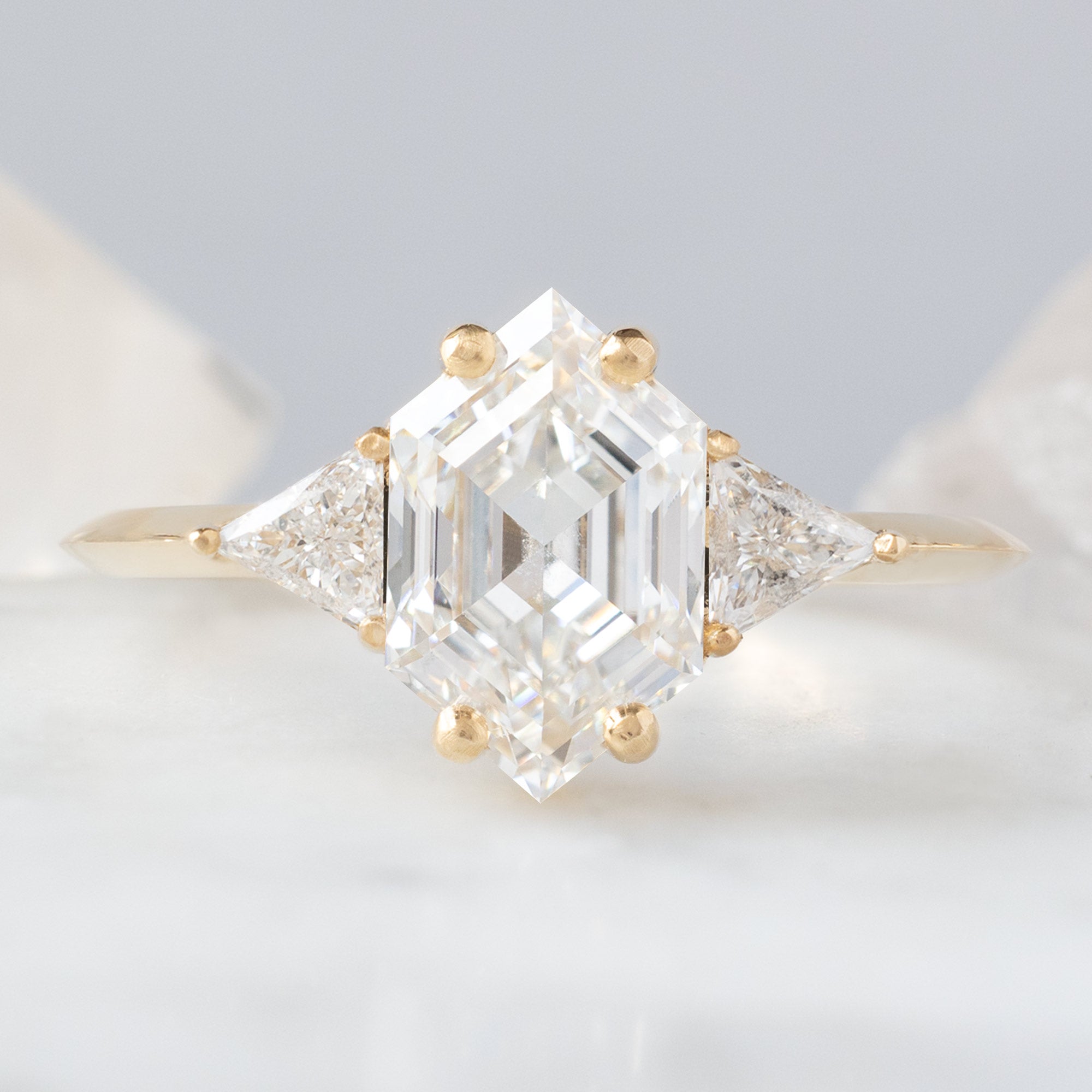 The Jade Ring with a Lab Grown White Hexagon Diamond in 14K Yellow Gold on White Marble