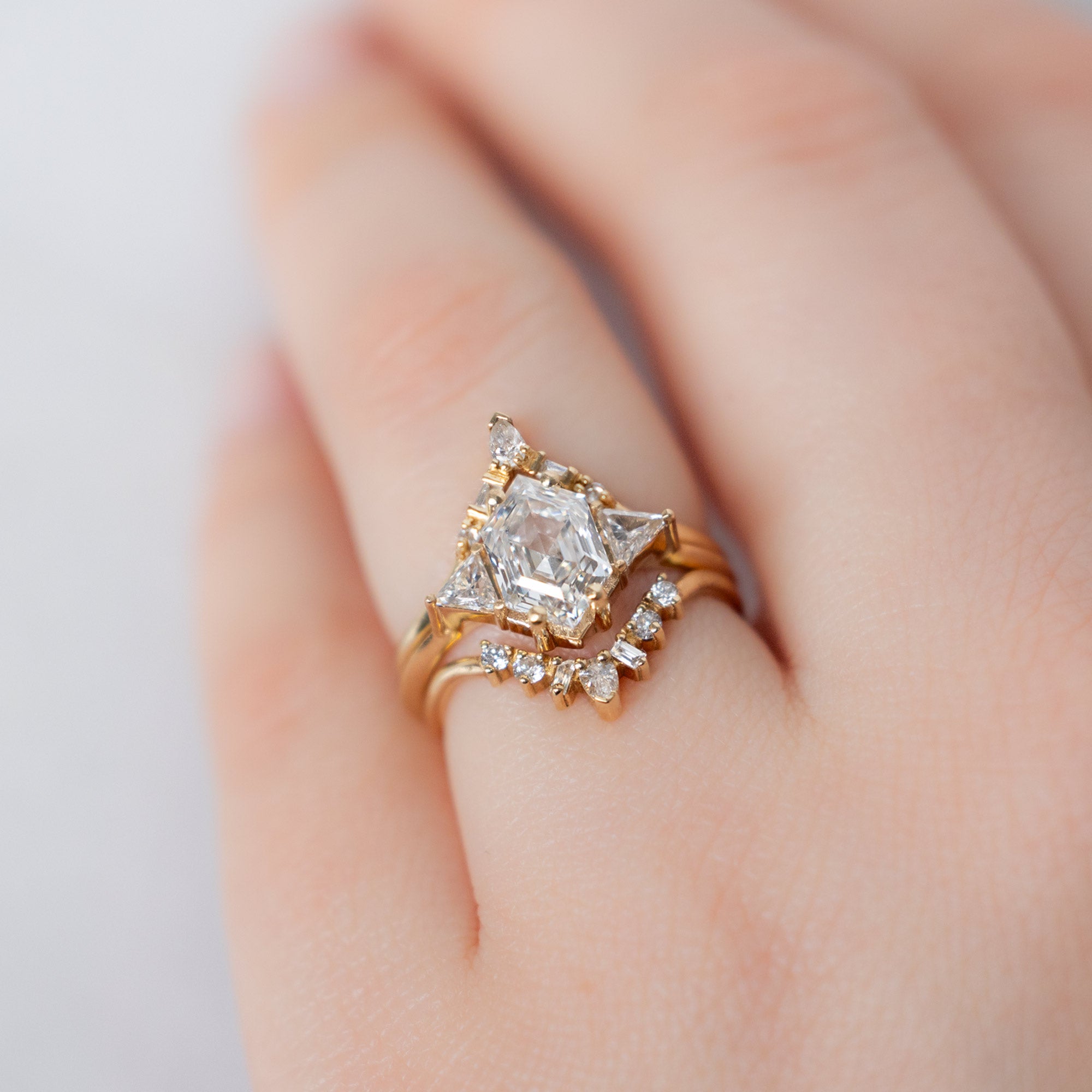 The Jade Ring with a Lab Grown White Hexagon Diamond in 14K Yellow Gold Stacked with White Diamond Stacking Bands on Model