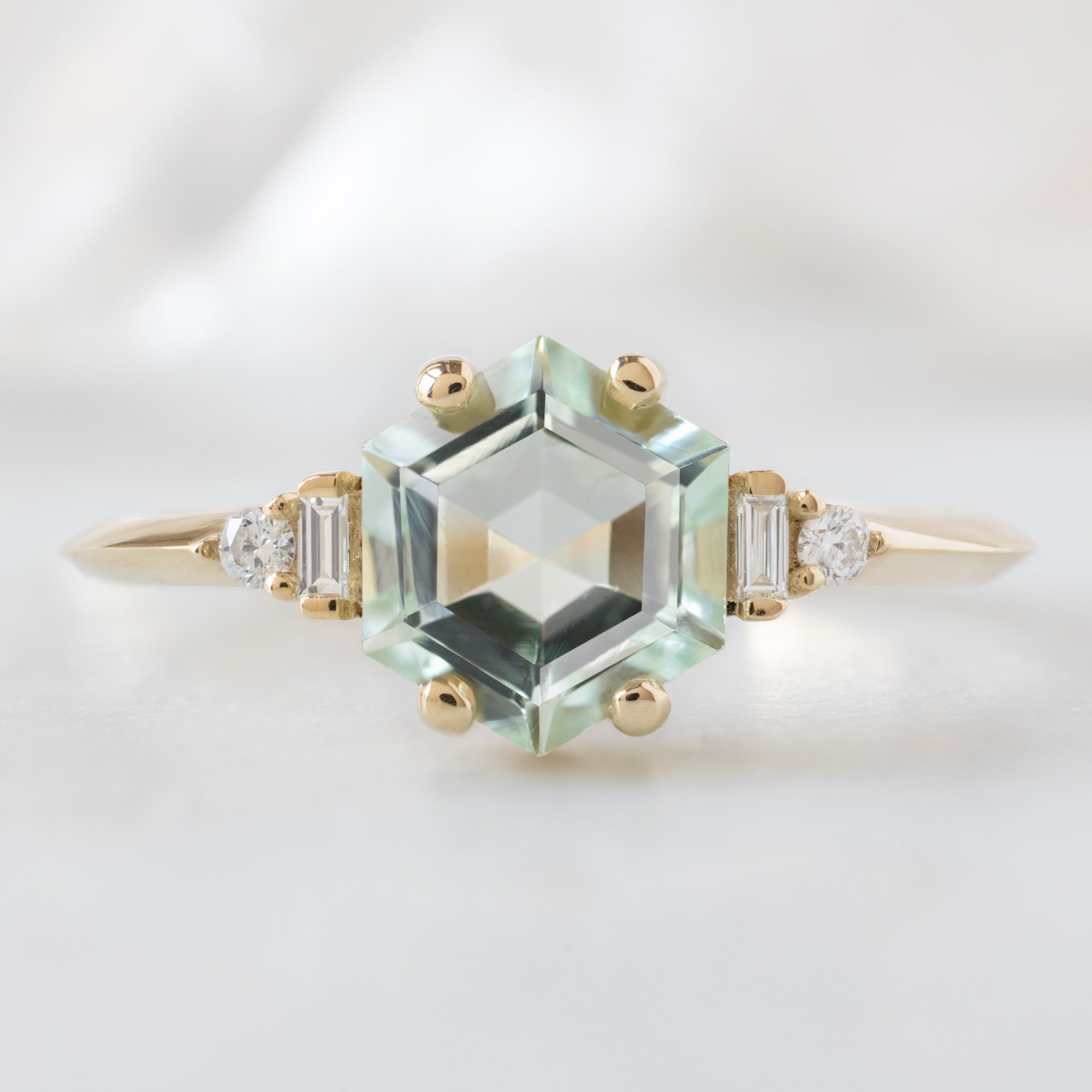 The Primrose Ring with a 1.05ct Hexagon Tourmaline in 14K Yellow Gold on White Marble Surface