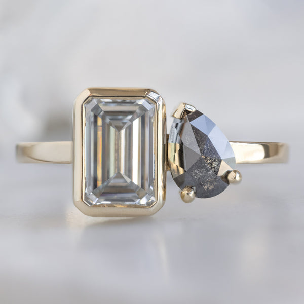 The You and Me Ring with a 1.25ct Emerald Cut Lab Grown White Diamond in 14K Yellow Gold on White Marble Surface