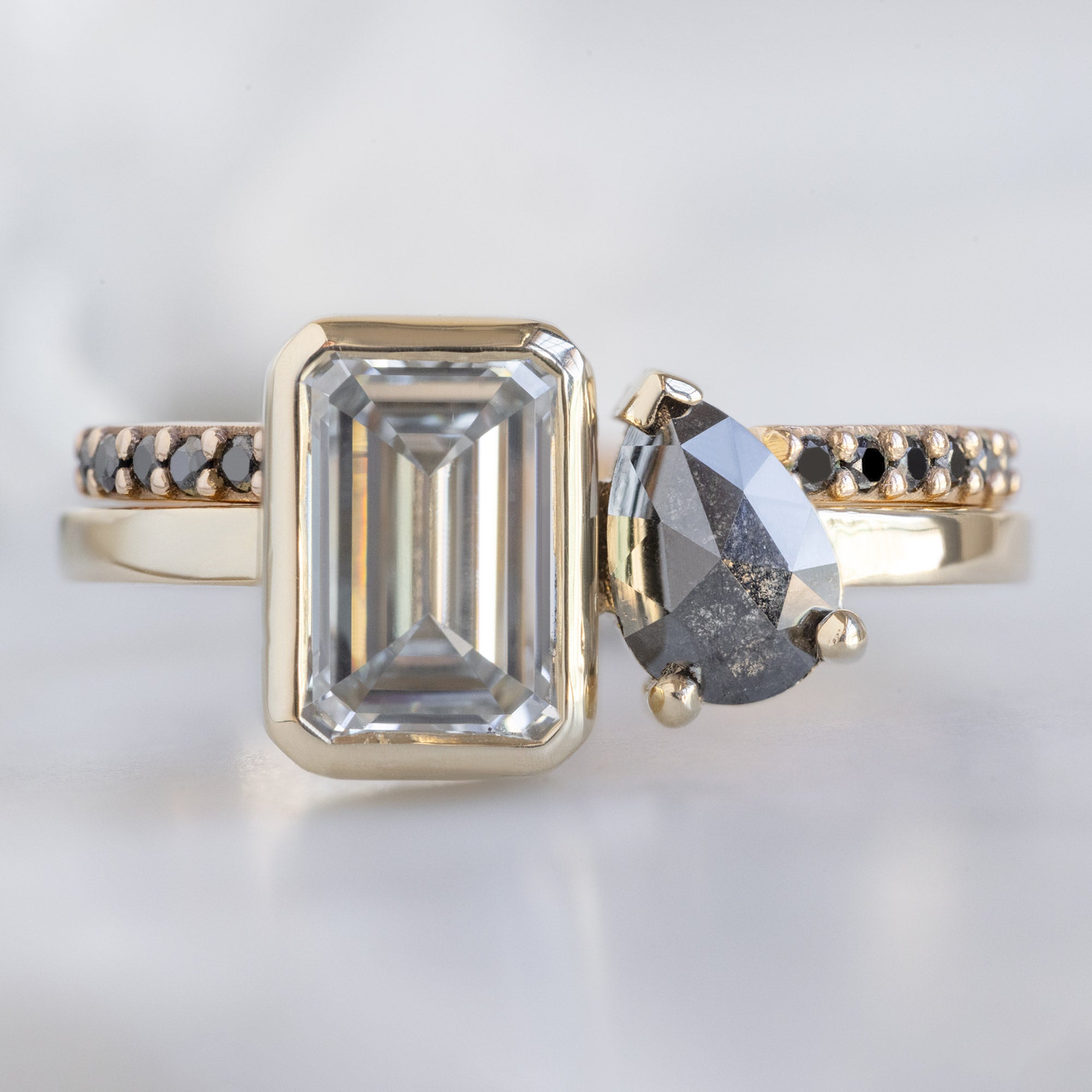 The You and Me Ring with a 1.25ct Emerald Cut Lab Grown White Diamond in 14K Yellow Gold Stacked with the Open Cuff Black Diamond Pavé Stacking Band