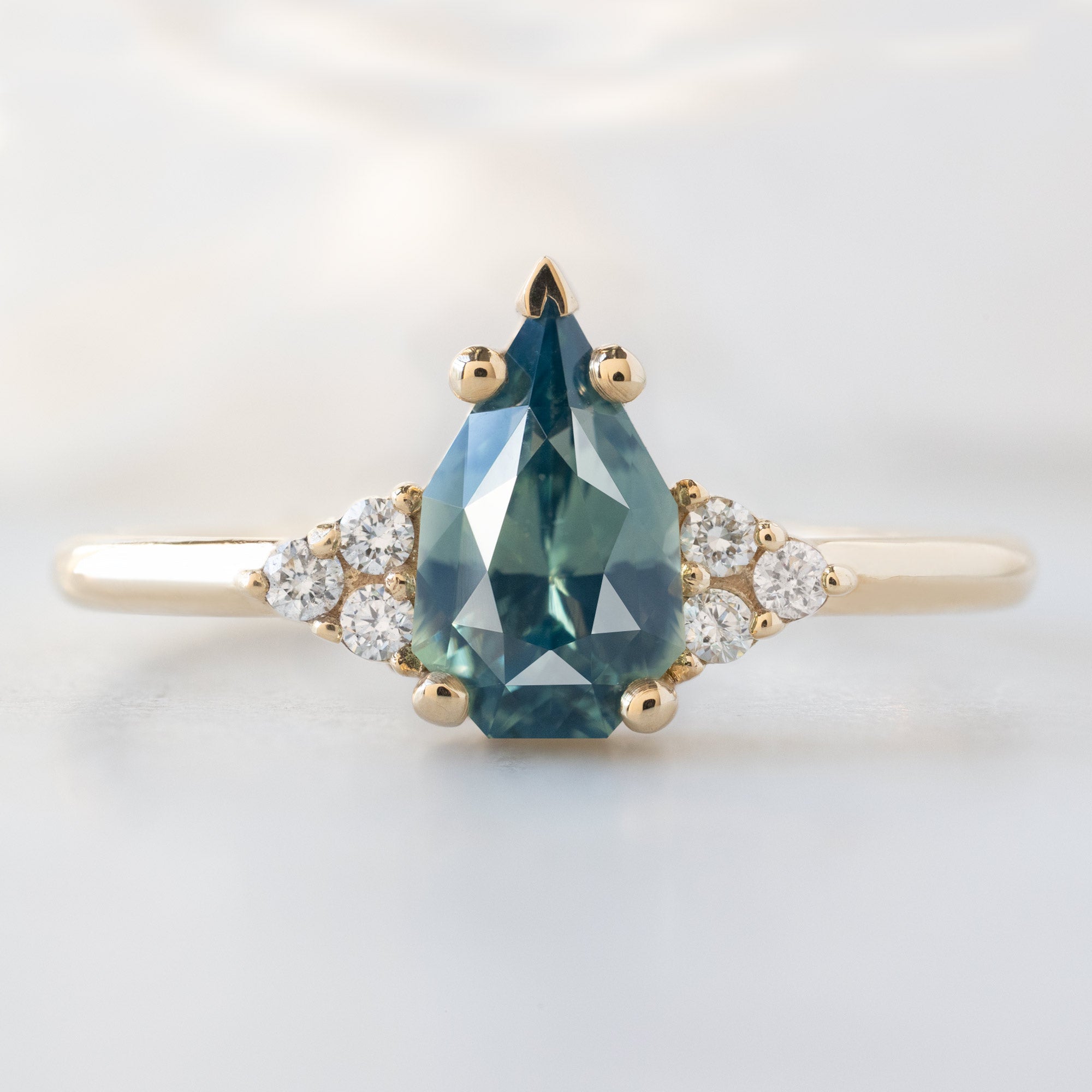 The Ivy Ring with a 1.07ct Geometric Montana Bicolor Sapphire in 14K Yellow Gold on White Marble Surface