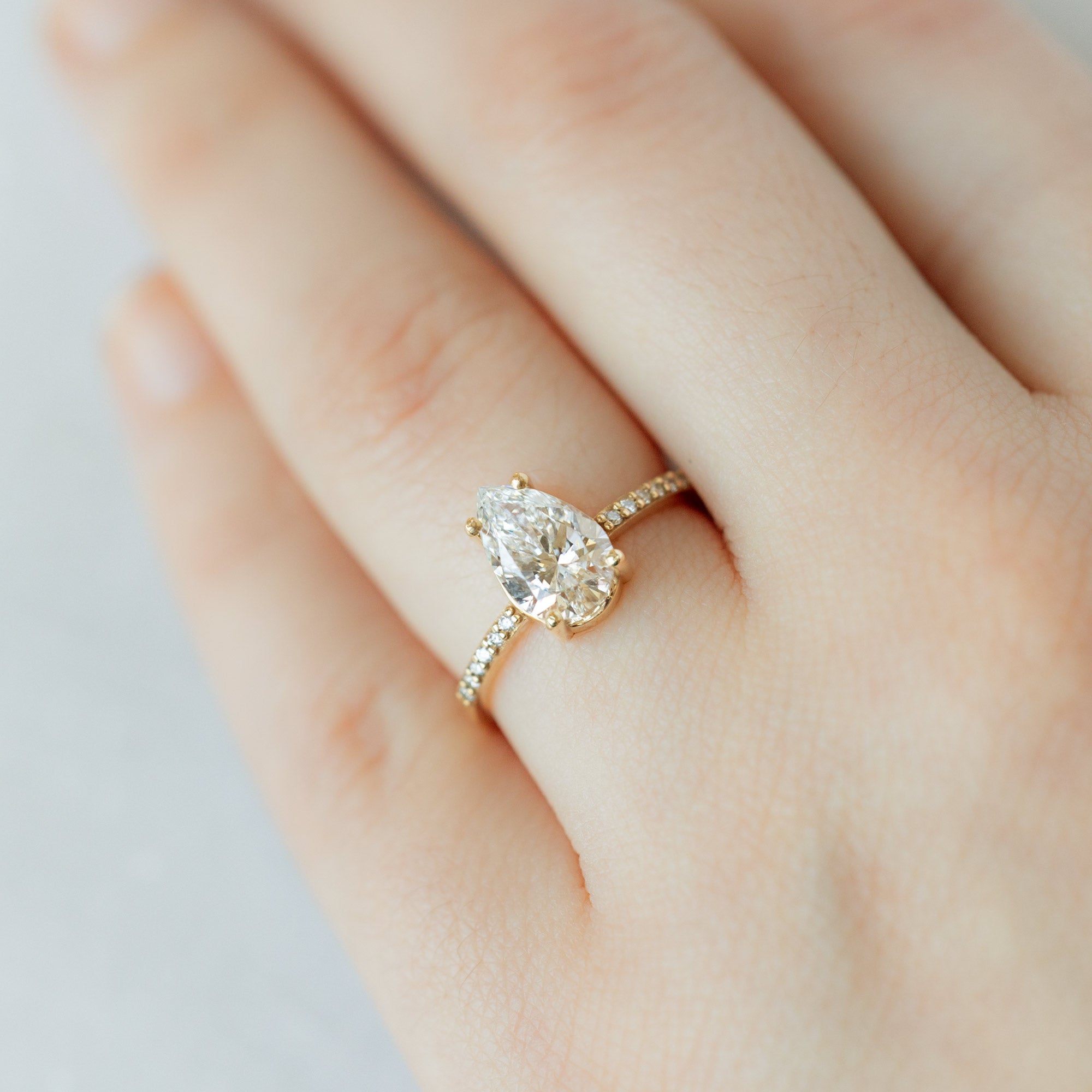 The Willow Ring with a 1.50ct Pear Lab Grown White Diamond in 14K Yellow Gold on Model