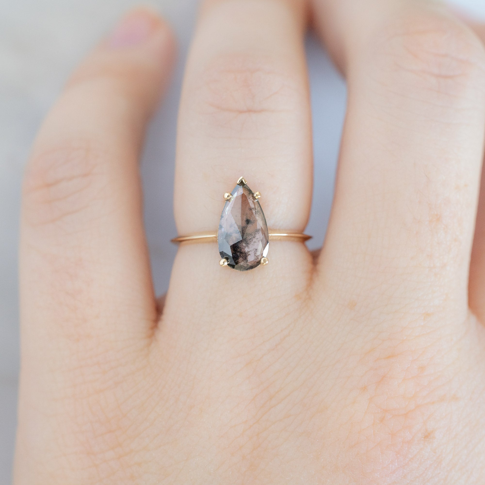 The Sage Ring with a 1.19ct Pear Lab Grown Salt and Pepper Diamond in 14K Yellow Gold on Model