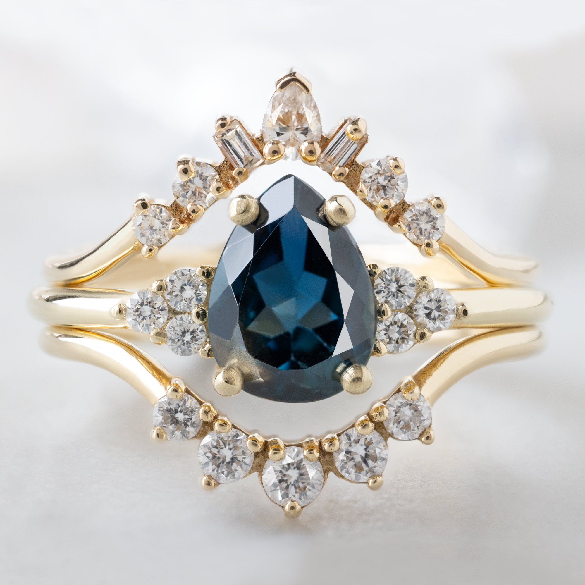 buy:geometric-white-diamond-sunburst-stacking-band-14k-or-18k-yellow-gold,the-ivy-ring-1-36ct-pear-blue-sapphire-in-14k-yellow-gold,round-white-diamond-sunburst-stacking-band-14k-or-18k-yellow-gold