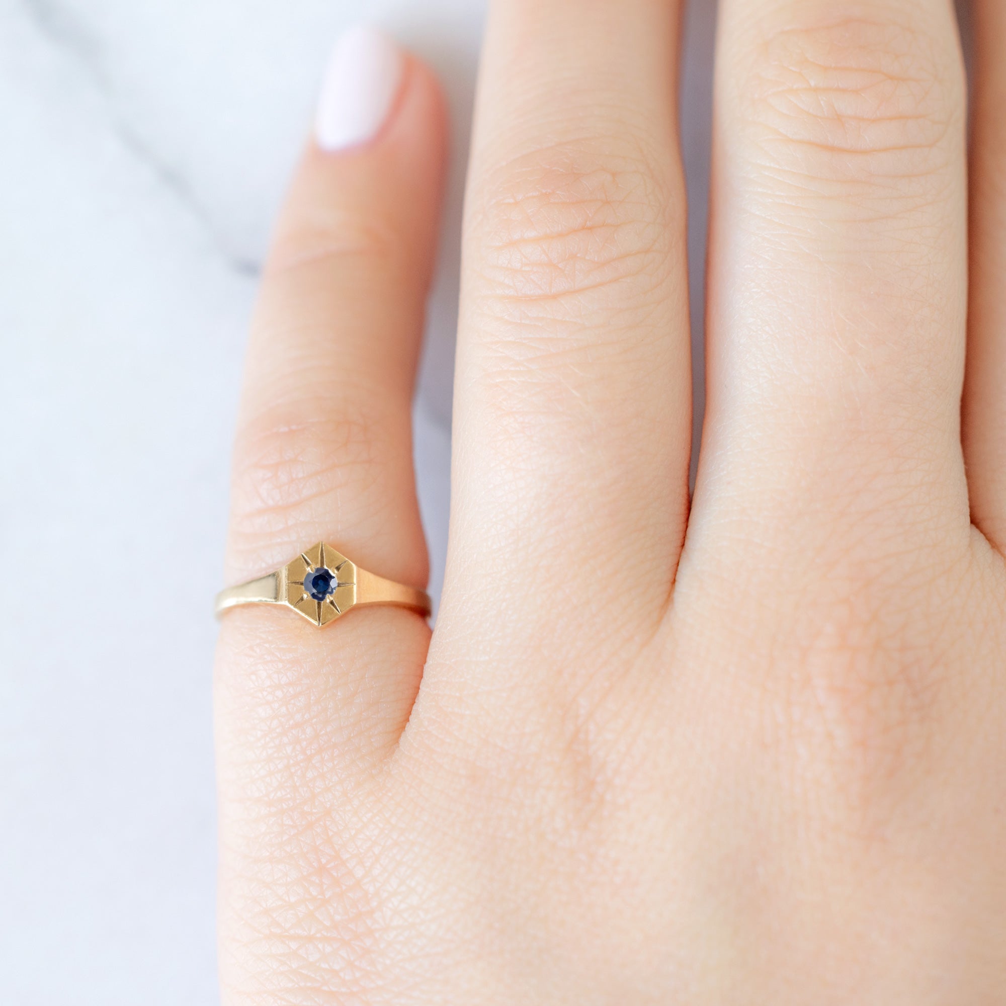 Custom Blue Sapphire Birthstone Signet Ring | 10K Yellow Gold displayed on model's left hand pinky finger. 