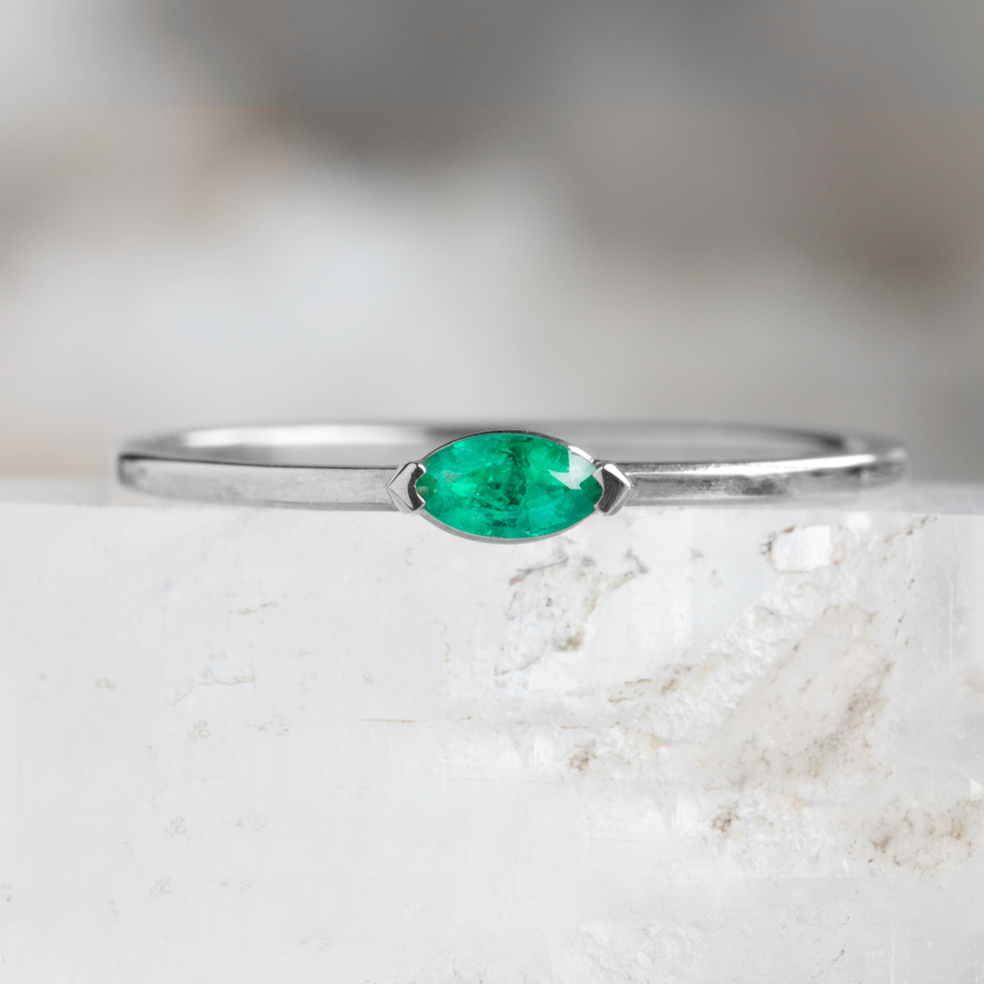 The Teensy Emerald Ring in 14k White Gold on white crystal