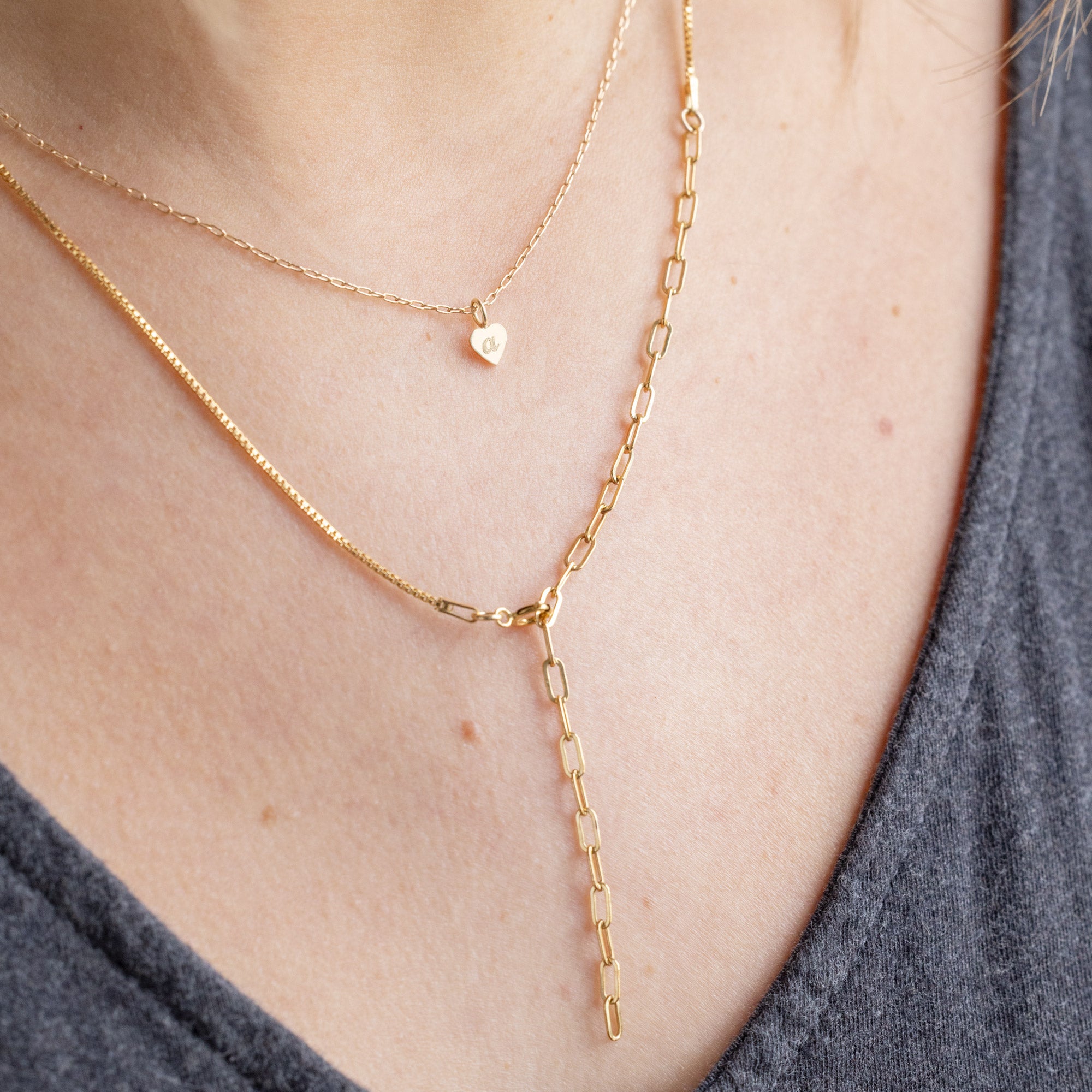 The Heart Pendant Necklace with an engraved 'A' in Yellow Gold Layered with the 4-in-1 Chain Necklace on Model
