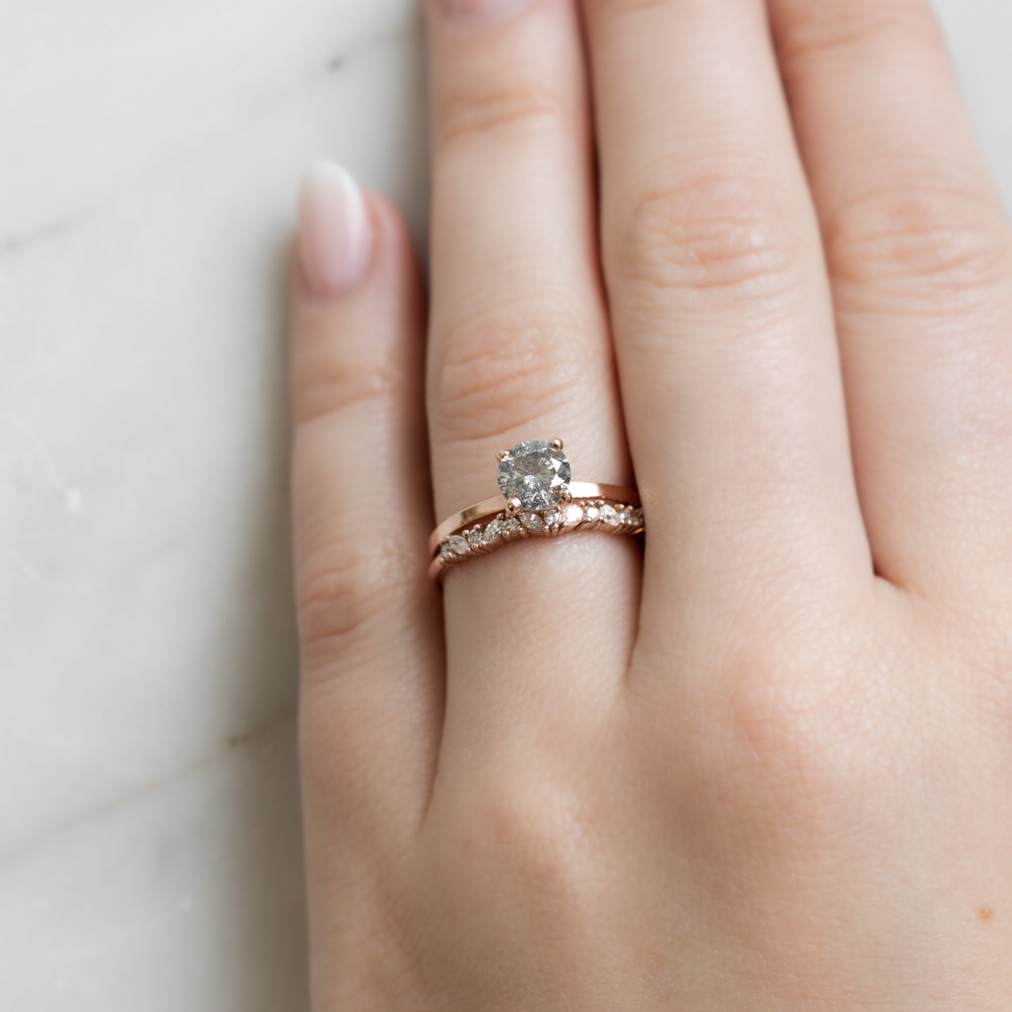 The Marquise Confetti Wedding Band in 14K Rose Gold Stacked with Round Salt and Pepper Diamond Engagement Ring on Model