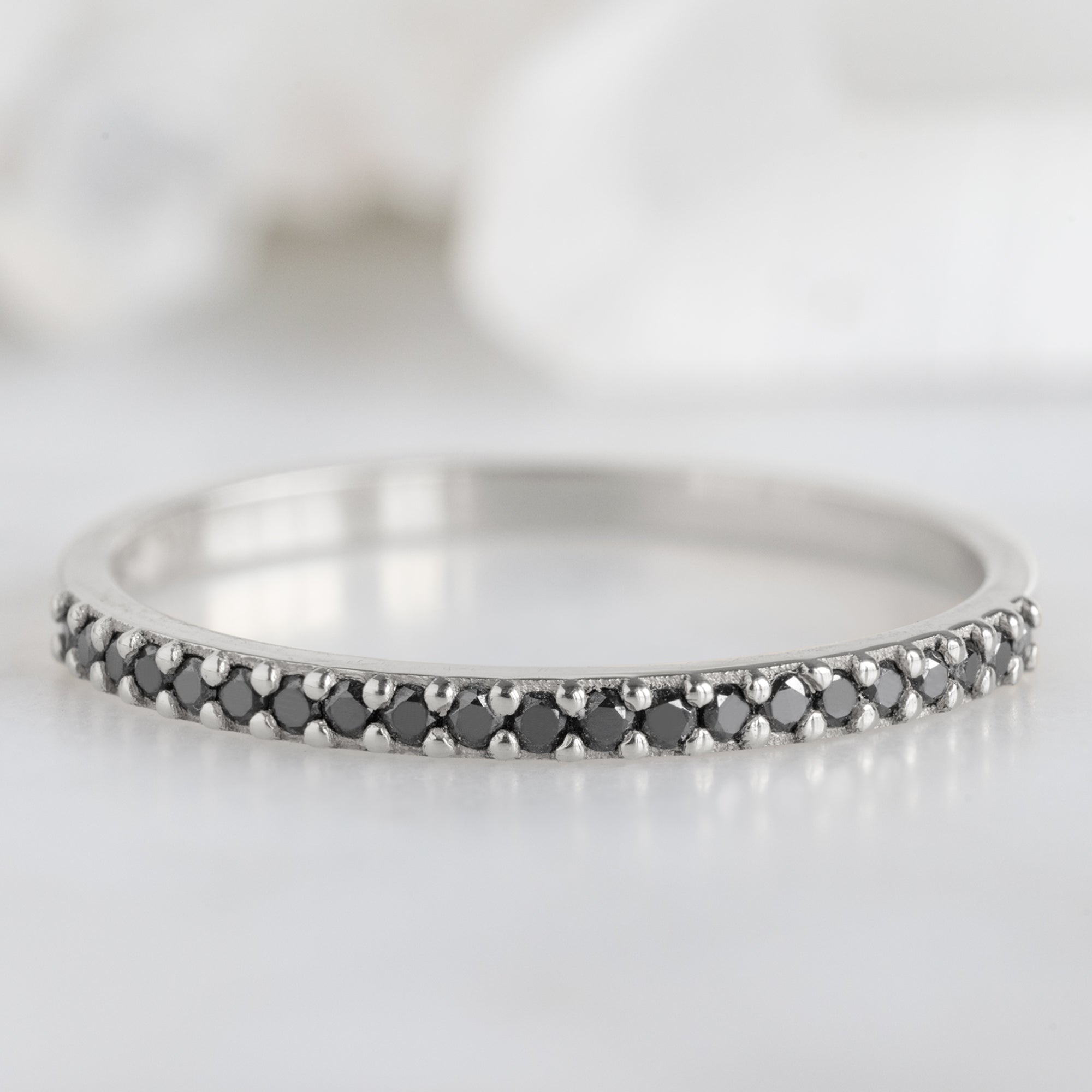 The Black Diamond Pavé Wedding Band in 14K White Gold on White Marble